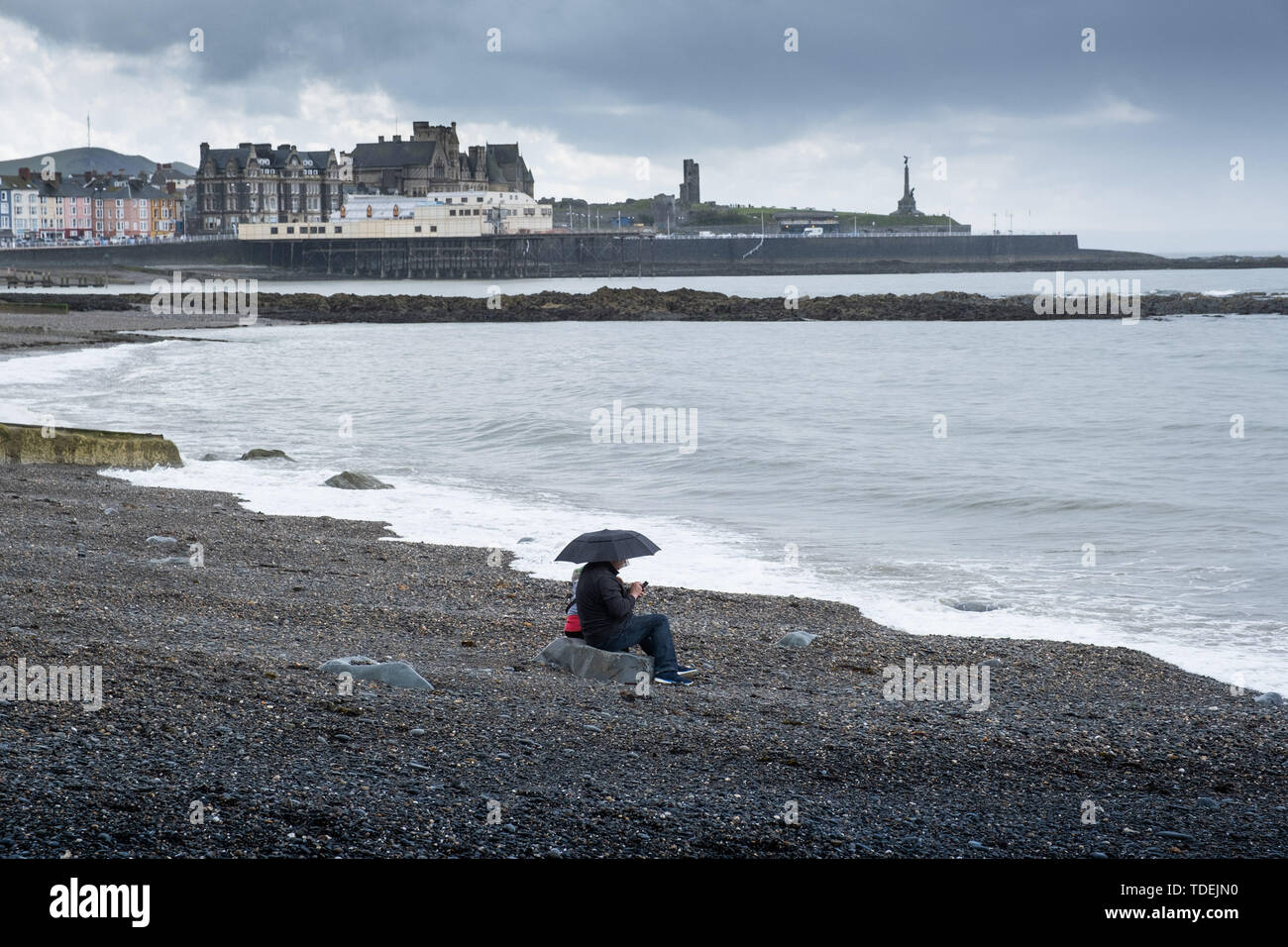 Aberystwyth Wales UK, Sabato 15 Giugno 2019 UK Meteo: un paio di avere la spiaggia a se stesse su un grigio e bagnato Pomeriggio al mare in Aberystwyth , west wales, come i deprimenti bagnato e molto unsesonal giugno 'Summer' meteo continua la sua attesa sul paese Photo credit Keith Morris / Alamy Live News Foto Stock