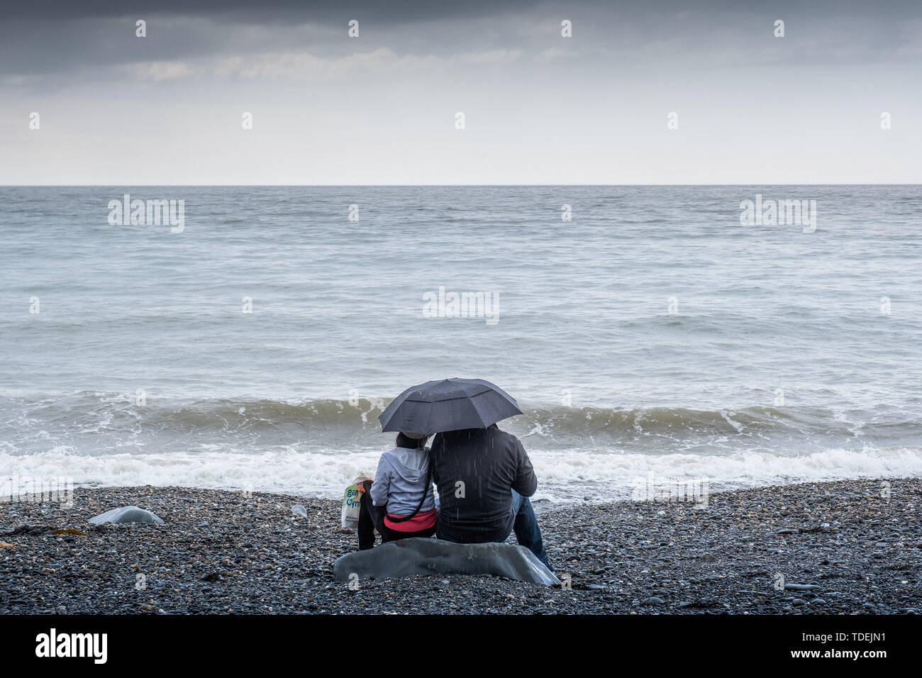Aberystwyth Wales UK, Sabato 15 Giugno 2019 UK Meteo: un paio di avere la spiaggia a se stesse su un grigio e bagnato Pomeriggio al mare in Aberystwyth , west wales, come i deprimenti bagnato e molto unsesonal giugno 'Summer' meteo continua la sua attesa sul paese Photo credit Keith Morris / Alamy Live News Foto Stock