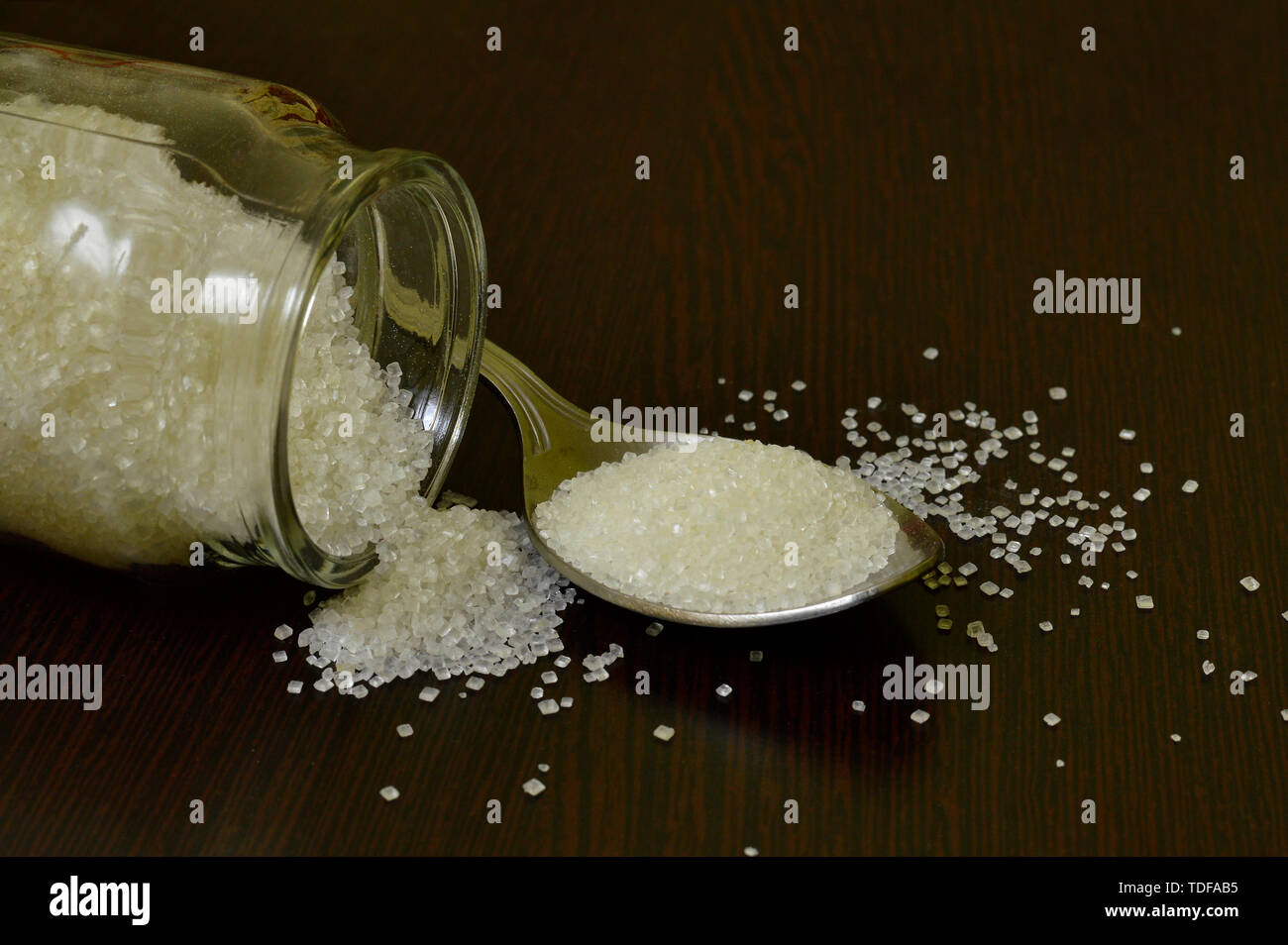 Cucchiaio e zucchero sul tavolo. Foto Stock