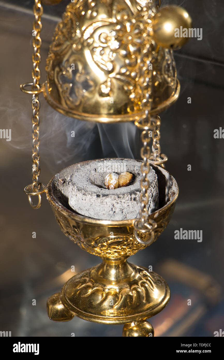 Mano con turibolo brucia incenso su carbone caldo interno, durante la  celebrazione nella Chiesa ortodossa. Profumo fumo che sale verso l'alto.  Close-up. Fotogr verticale Foto stock - Alamy