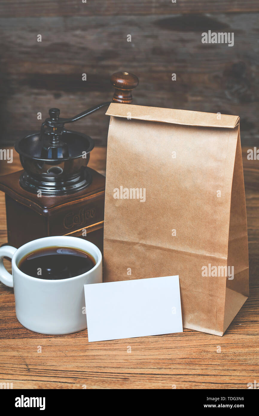 Blank business cards e la tazza di caffè sul tavolo di legno. Corporate branding stazionaria mock up. Foto Stock
