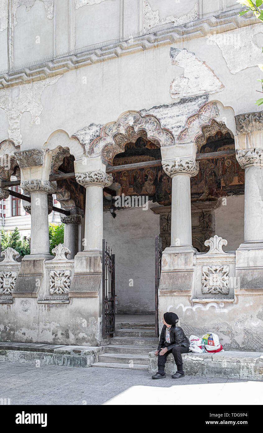 Bucarest, Romania - 30 Maggio 2019: povera donna seduta sulle scale di fronte la chiesa Coltei, uno dei monumenti architettonici più representat Foto Stock