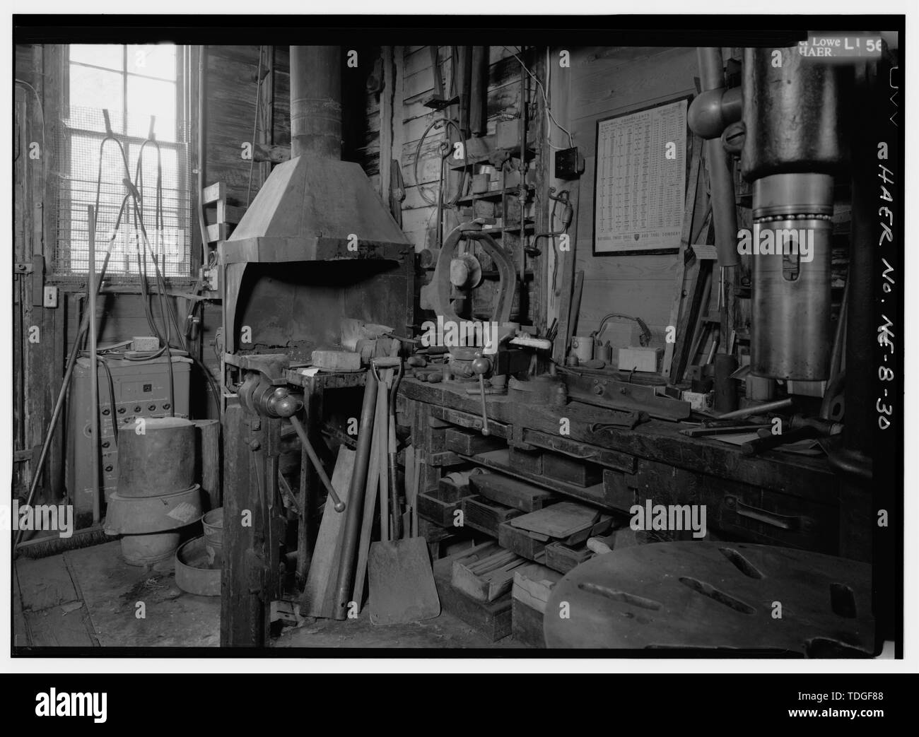 A NORD-EST DI FABBRO AREA SHOP IN angolo nordest della fabbrica. Una morsa da banco sorge in primo piano a sinistra di fronte alla fucina con cappuccio. Montato sul banco di lavoro è la colata principale da un mulino a vento di Eli, utilizzato come maschera per il supporto di pezzi durante il cuscinetto BABBITT operazione di colata. - Il mulino a vento di Kregel azienda fabbrica, 1416 Central Avenue, Nebraska City, Otoe County, NE Foto Stock