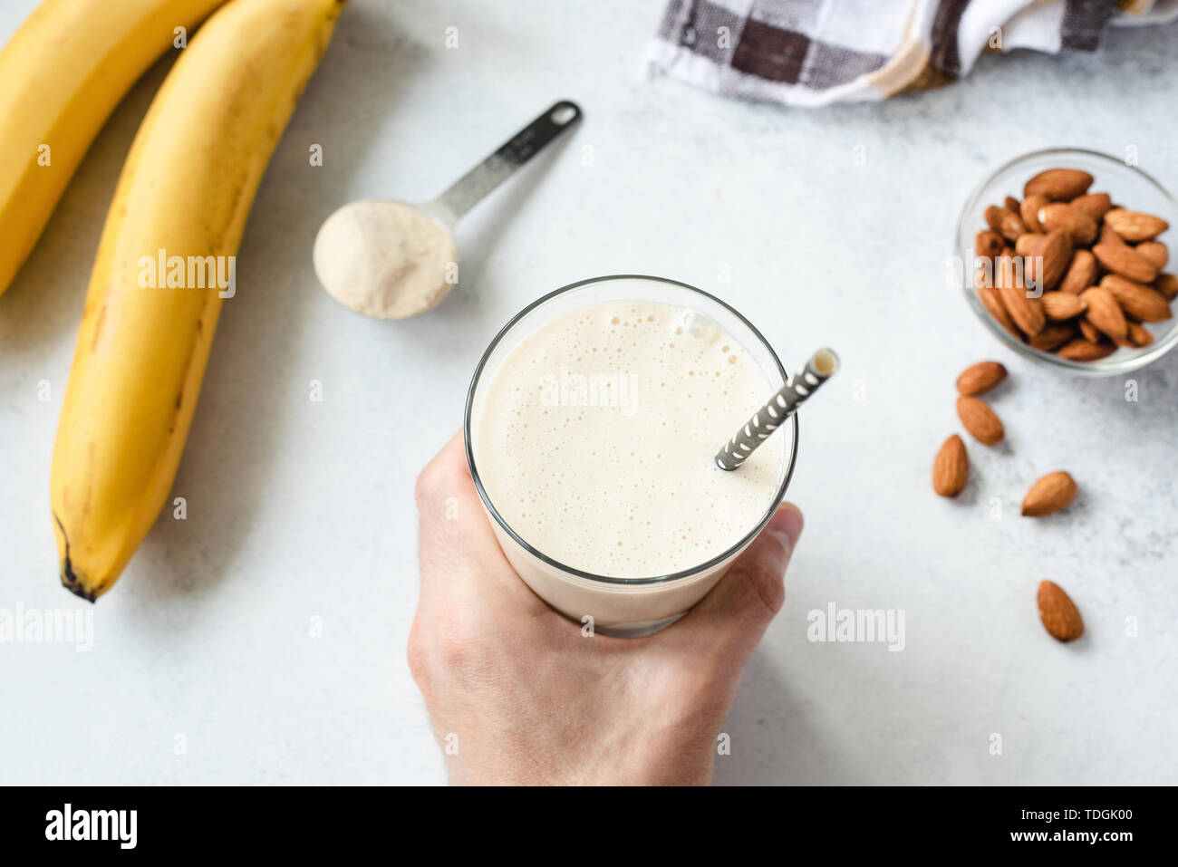 Proteina frullato di banana o frullato. Man mano dell azienda di vetro sano vegetariano vegano smoothie Foto Stock