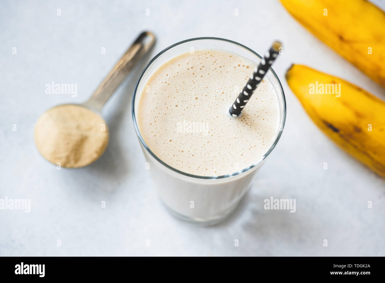 Proteina vegano banana shake o frappè in vetro. Vista dall'alto, il fuoco selettivo Foto Stock