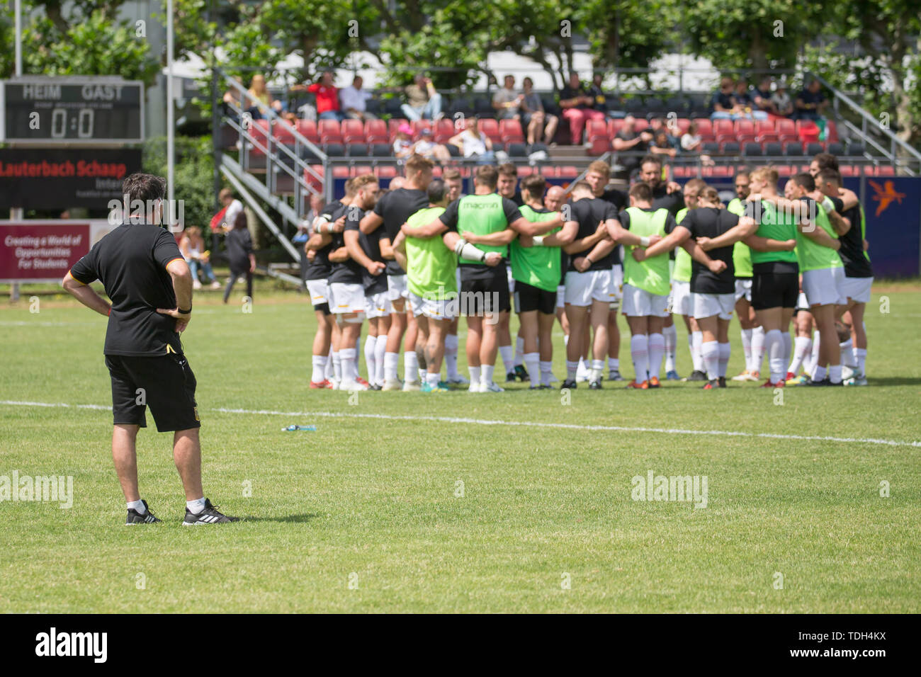 Hessen, Germania. Il 15 giugno, 2019. Rugby: EM, retrocessione, Germania - Portogallo. Allenatore Mike Ford (Germania) osserva il suo team, il quale ha formato un team cerchio prima di iniziare il gioco. Credito: dpa picture alliance/Alamy Live News Foto Stock