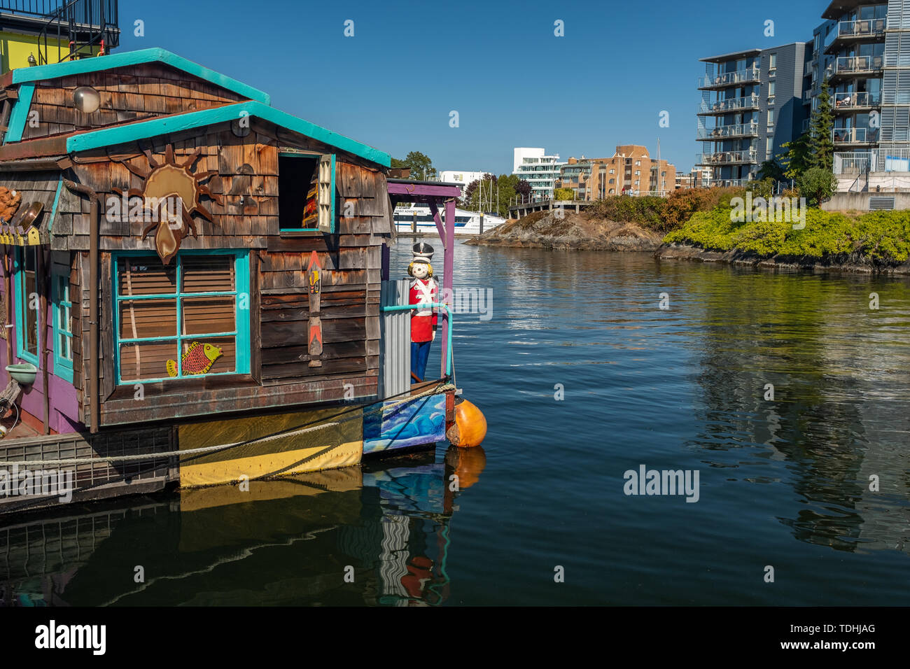 Victoria, Isola di Vancouver, British Columbia, Canada, Luglio 8, 2018: le case galleggianti in Victoria sullo sfondo di un appartamento ​modern blocco. Foto Stock