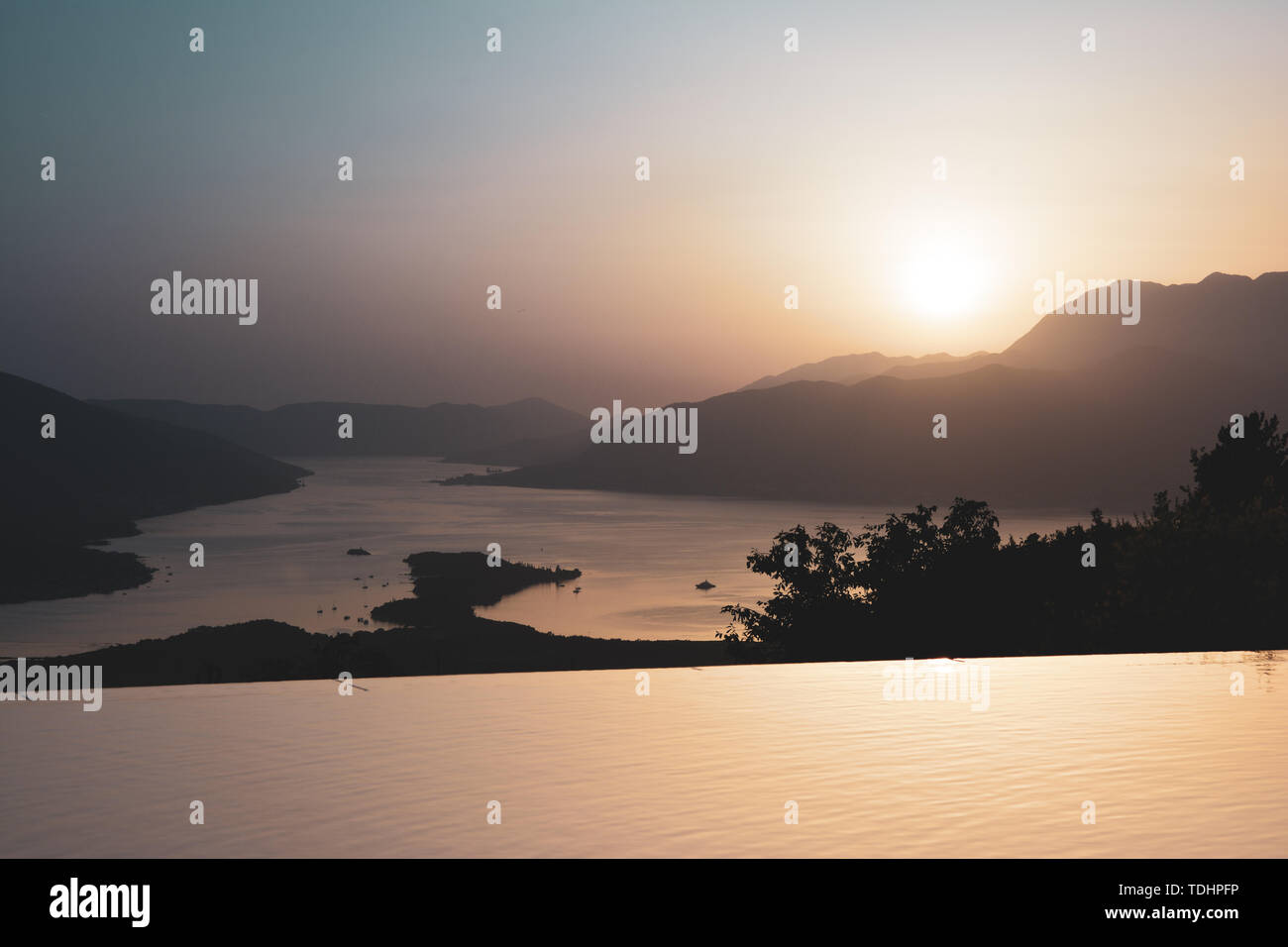 Tramonto dietro le montagne sullo sfondo del mare. Foto Stock