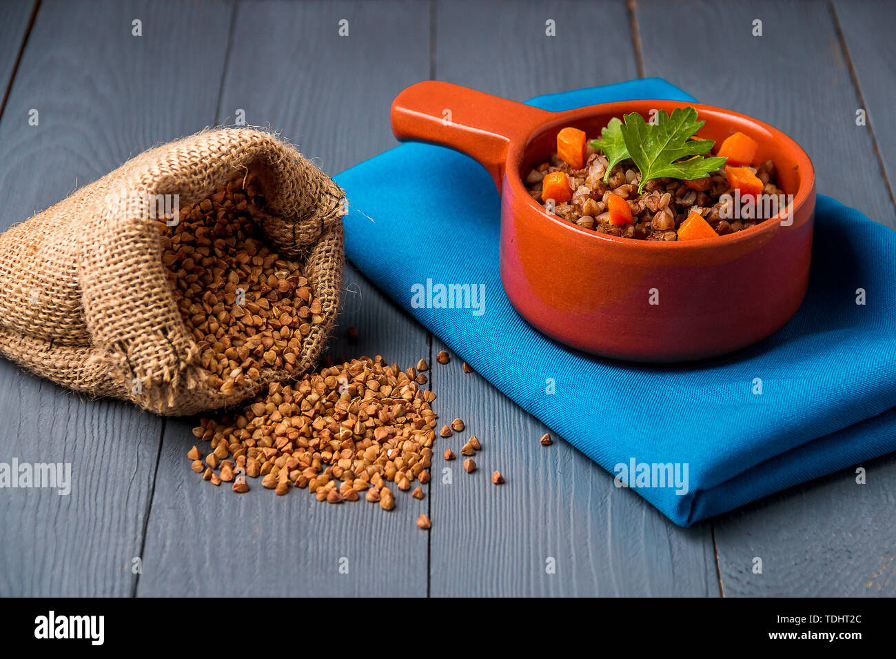 Ciotola marrone del gustoso grano saraceno porridge grigio su un tavolo di legno. Foto Stock