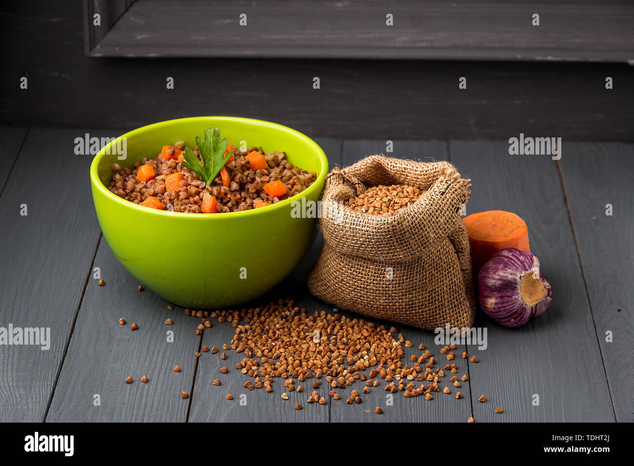 Ciotola verde di gustoso grano saraceno porridge grigio su un tavolo di legno. Foto Stock