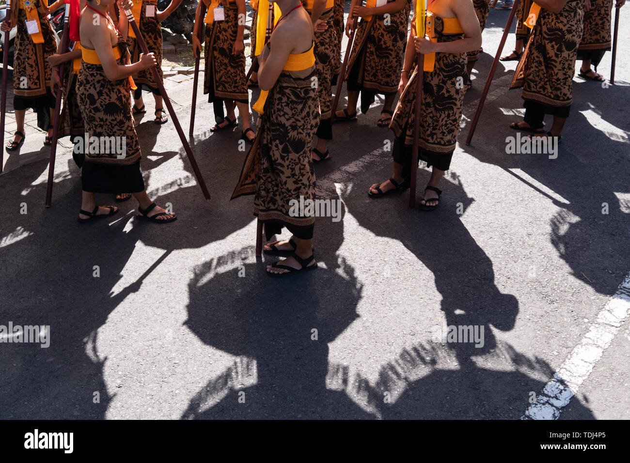 Ombra del gruppo del ballerino di danza Balinese in costumi etnici con tradizionale ombrelloni colorati sulla cerimonia Indù parade durante il festival tempio. Balines Foto Stock