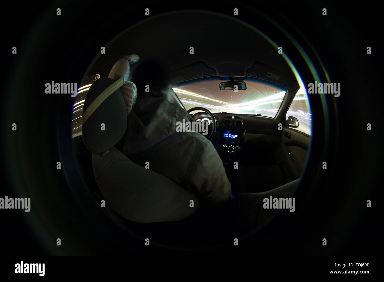 Autista in auto all'interno della vista attraverso la lente Foto Stock