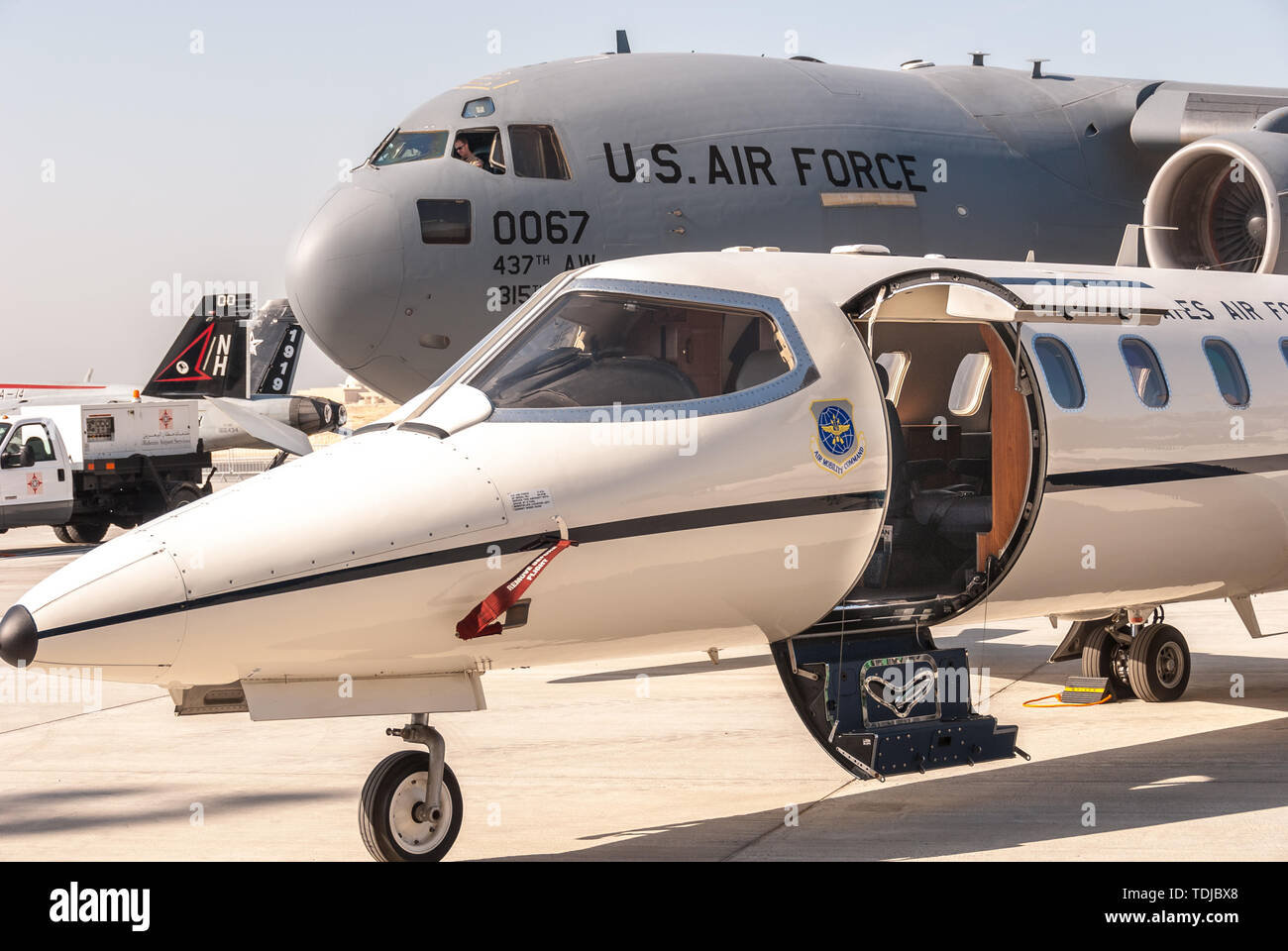 Aria Mobilità il comando Learjet con C-130 Hercules in background Foto Stock