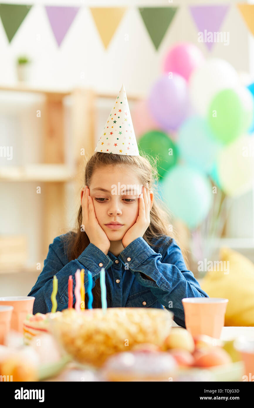 Ritratto di triste ragazza adolescente seduto da solo al tavolo di partito per il suo compleanno Foto Stock
