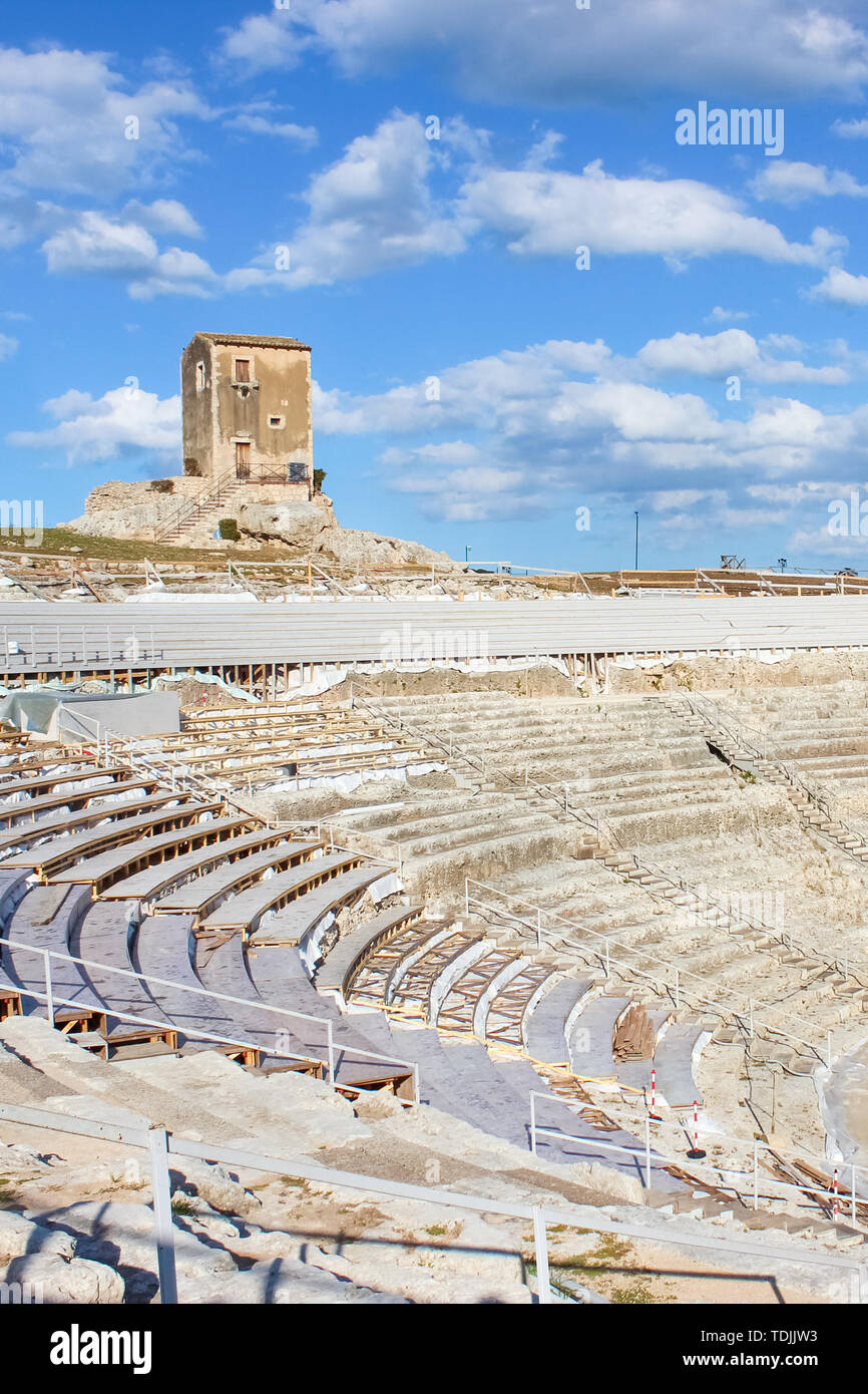 Famoso teatro Greco di Siracusa, Sicilia, Italia con cielo blu. Antico sito, i punti di interesse storico. Popolare attrazione turistica. Stadio e tribune pronto per giochi all'aperto, concerti e manifestazioni culturali. Foto Stock