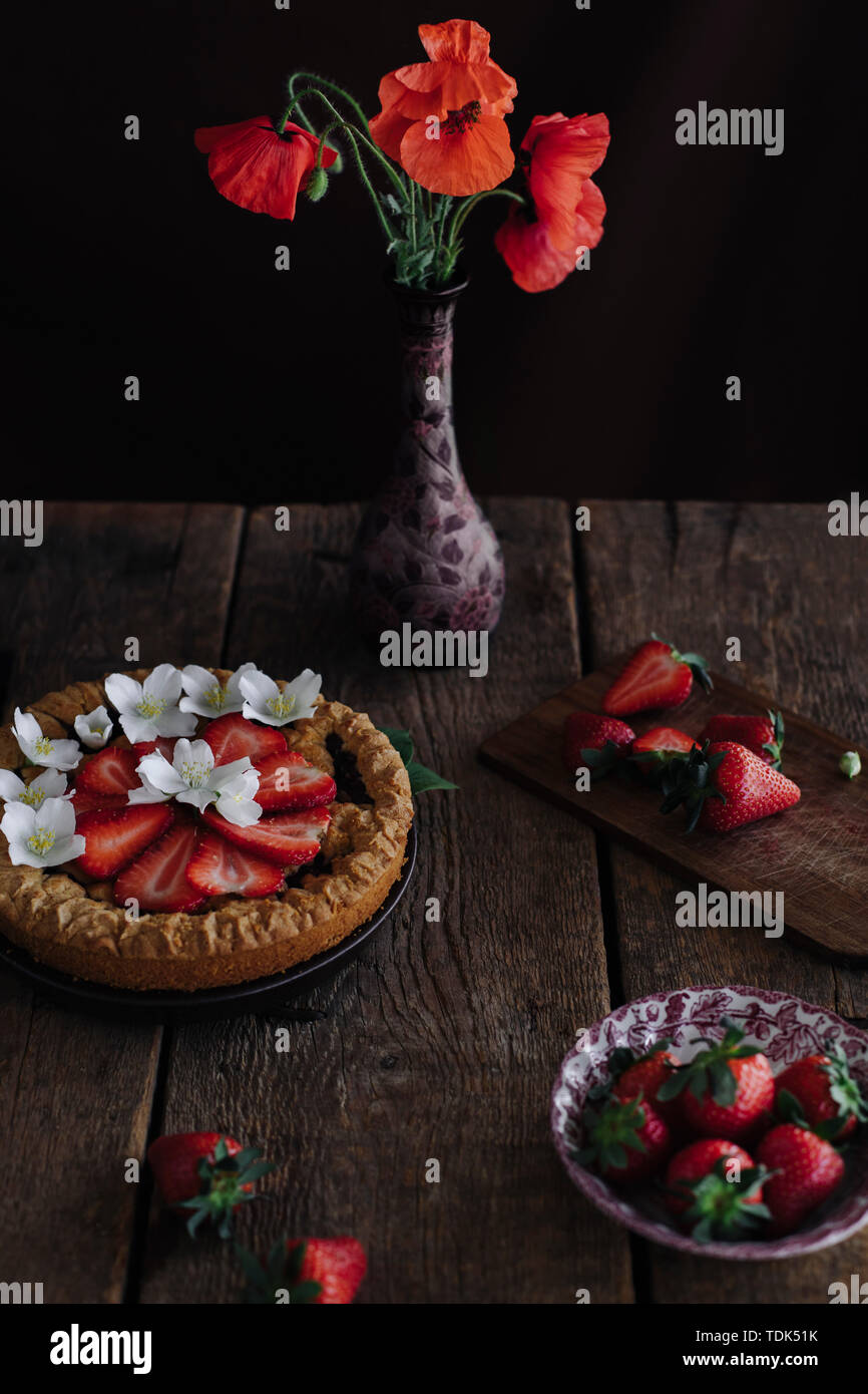 Crostata di fragole con semi di papavero fiori su un tavolo di legno Foto Stock