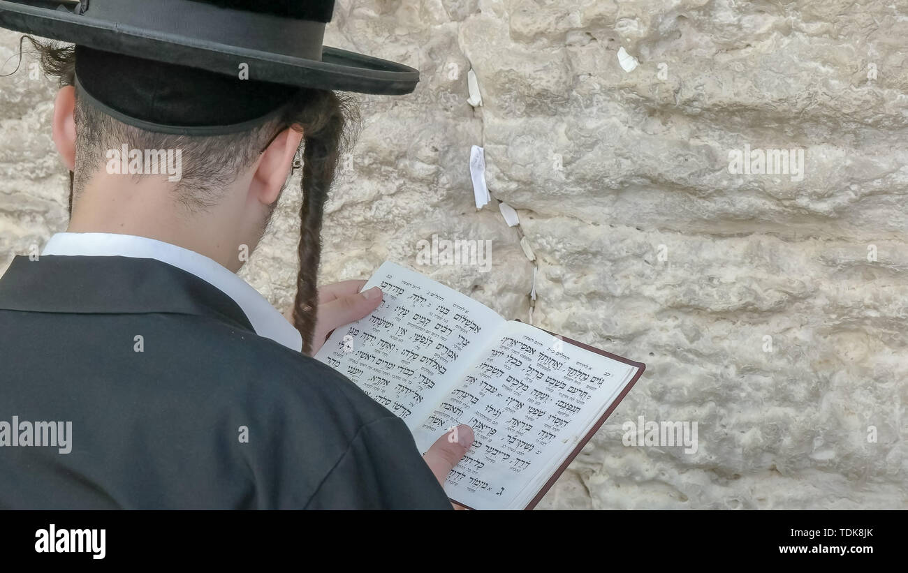 Close up di un uomo ebraico adorare con un libro di preghiera al Muro Occidentale di Gerusalemme, Israele Foto Stock
