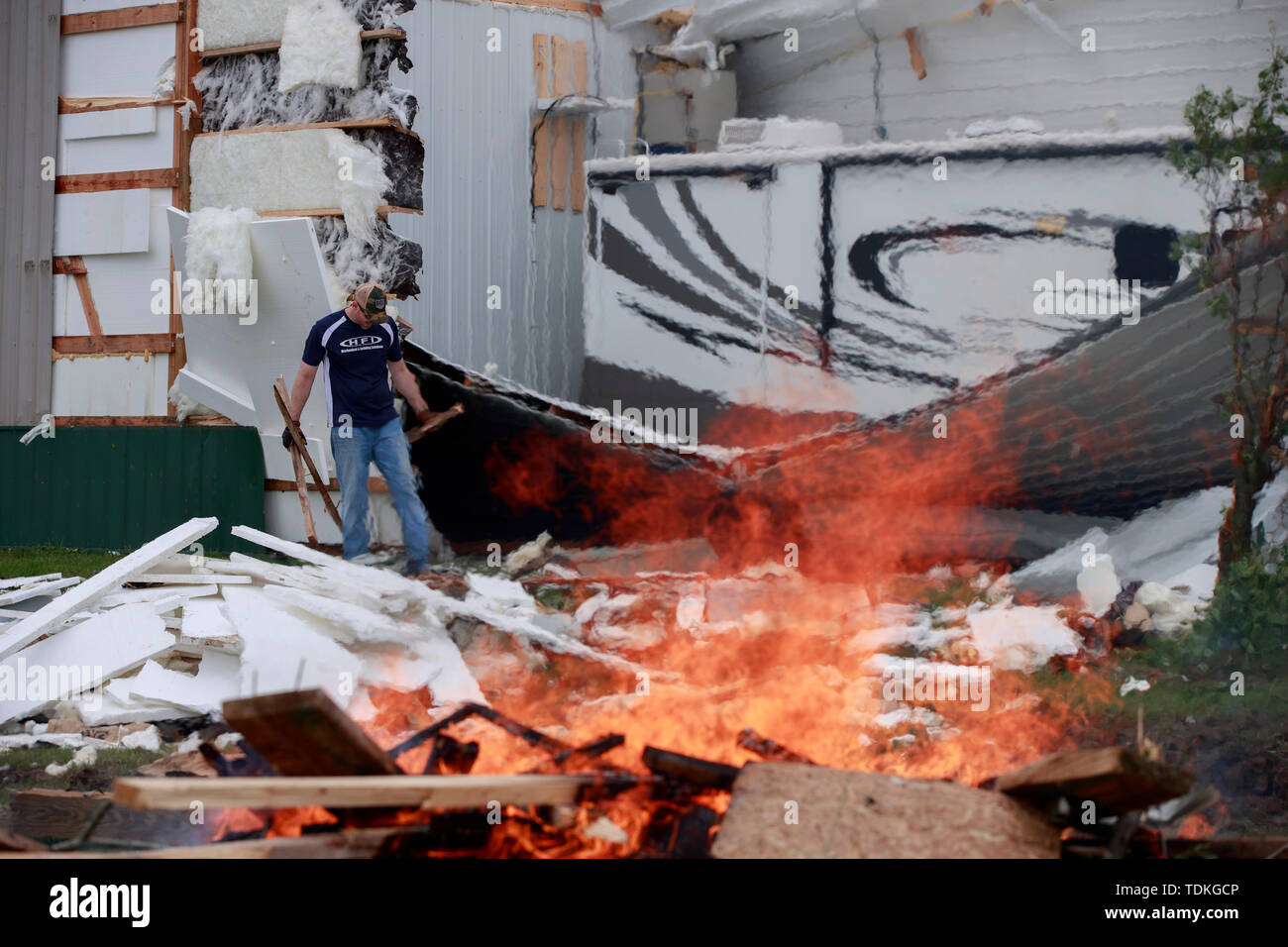 Ellettsville, Indiana, Stati Uniti d'America. 16 Giugno, 2019. La masterizzazione di detriti in corrispondenza di un edificio danneggiato sulla strada Flatwoods, durante l'indomani. Un tornado ha colpito la zona lasciando una patch di danni da Greene County a nord della Contea di Monroe distruggendo alberi, casa, auto e lasciando un percorso di detriti e vivere le linee di potenza sul terreno nella sua scia. Credito: SOPA Immagini limitata/Alamy Live News Foto Stock