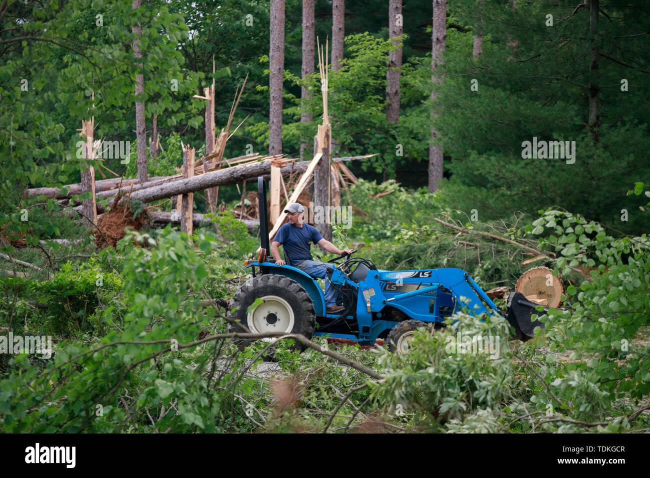 Ellettsville, Indiana, Stati Uniti d'America. 16 Giugno, 2019. La masterizzazione di detriti in corrispondenza di un edificio danneggiato sulla strada Flatwoods, durante l'indomani. Un tornado ha colpito la zona lasciando una patch di danni da Greene County a nord della Contea di Monroe distruggendo alberi, casa, auto e lasciando un percorso di detriti e vivere le linee di potenza sul terreno nella sua scia. Credito: SOPA Immagini limitata/Alamy Live News Foto Stock