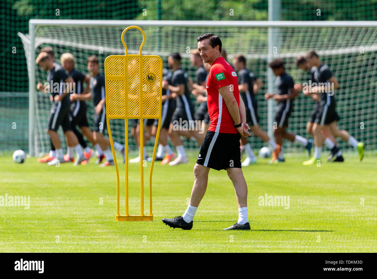 Aue, Germania. 17 Giugno, 2019. Calcio: Seconda Bundesliga, formazione kick-off FC Erzgebirge Aue. Coach Daniel Meyer corre attraverso la formazione di massa mentre i giocatori da eseguire in background. Credito: Robert Michael/dpa-Zentralbild/dpa - NOTA IMPORTANTE: In conformità con i requisiti del DFL Deutsche Fußball Liga o la DFB Deutscher Fußball-Bund, è vietato utilizzare o hanno utilizzato fotografie scattate allo stadio e/o la partita in forma di sequenza di immagini e/o video-come sequenze di foto./dpa/Alamy Live News Foto Stock