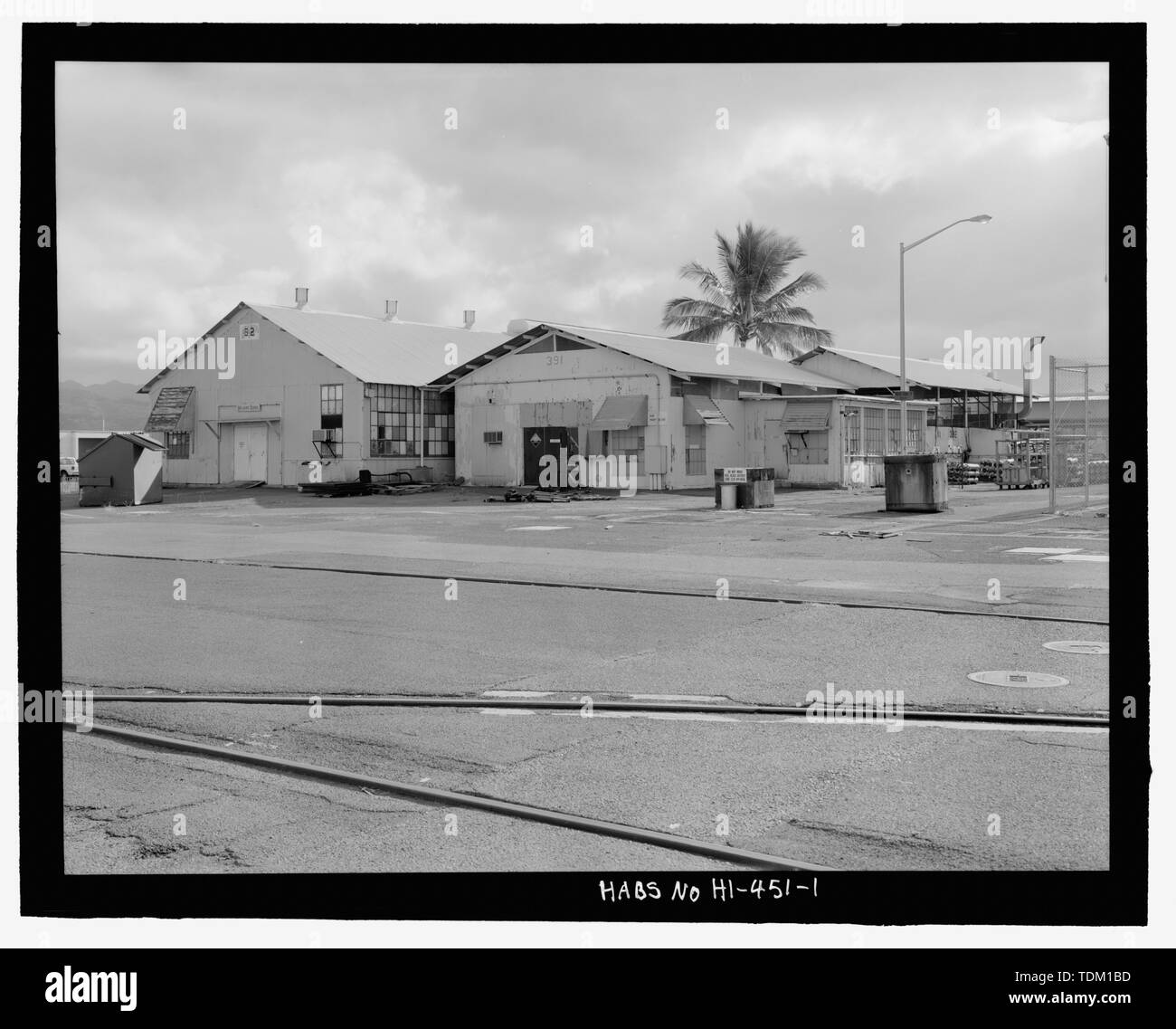 Complessiva vista contestuale di Edifici n. 92, 391, e 392, presa dal lato del molo, le rotaie della gru lungo bravo piloni in primo piano, Palm tree e via la luce al centro a destra, vista rivolta verso est-nord-est - STATI UNITI Base Navale, Pearl Harbor, Marine Railway n. 1 Accessori Casa e Apprendista Scuola di saldatura, aggiunte intersezione di Avenue B e Sesto Street, perla città e contea di Honolulu, HI Foto Stock