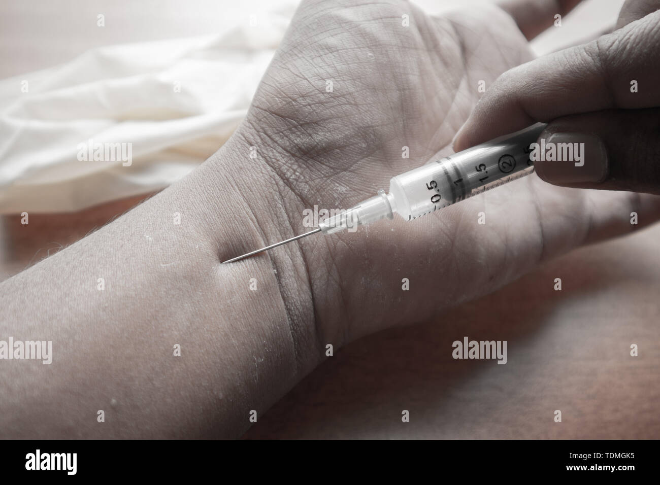 Primo piano della mano del narcotist iniettare una siringa in mano Foto Stock