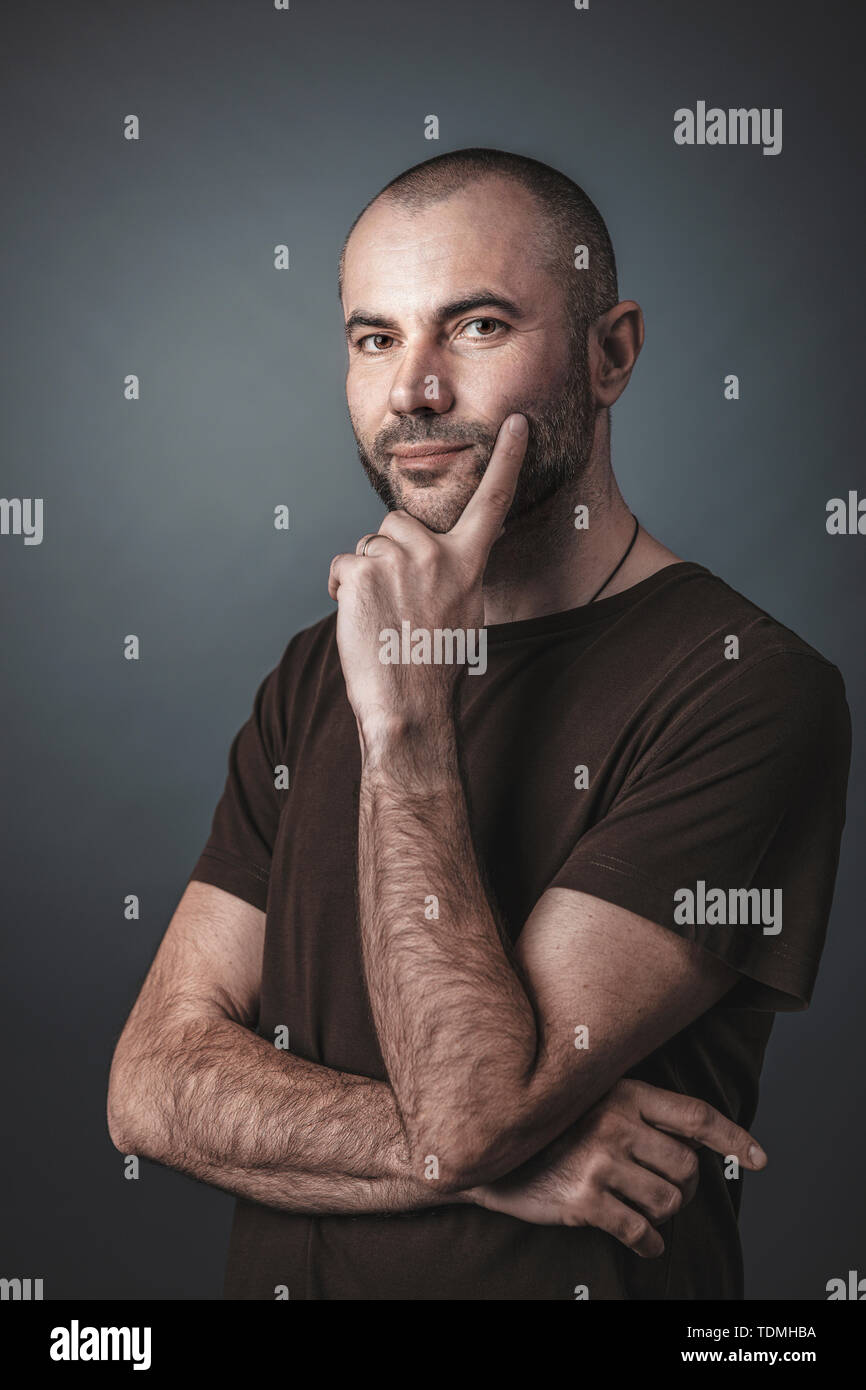 Ritratto di uomo caucasico con barba corta e testa, espressione pensosa. Foto Stock
