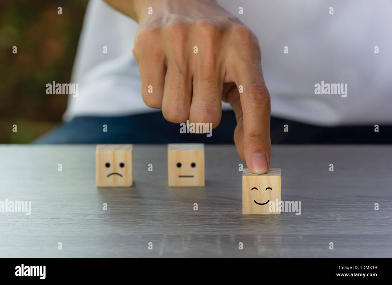 Conceptual il cliente ha risposto al sondaggio. Il client utilizzando la mano scegli faccia felice sorriso icona sul blocco di legno. Mostra che il cliente è molto satis Foto Stock