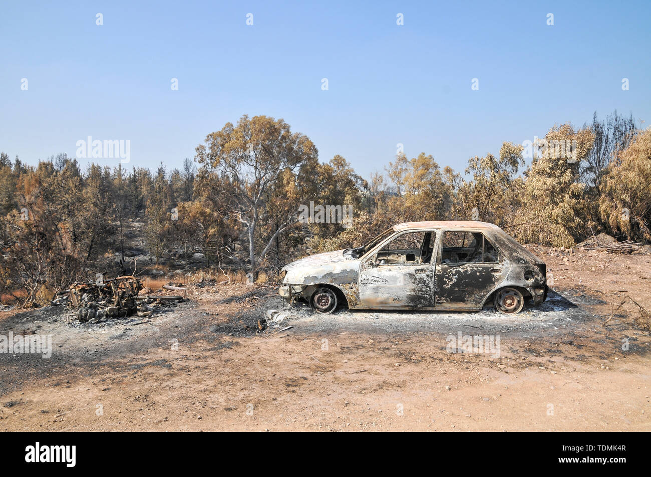 Il 23 maggio 2019, un incendio in un bosco devastato il villaggio di Mevo Modiim, Israele. Resti di un auto bruciata Foto Stock