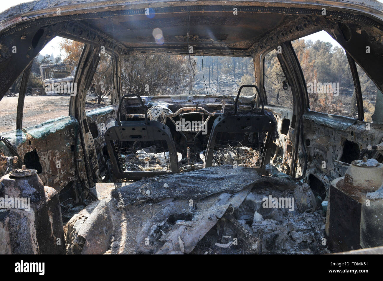 Il 23 maggio 2019, un incendio in un bosco devastato il villaggio di Mevo Modiim, Israele. Resti di un auto bruciata Foto Stock