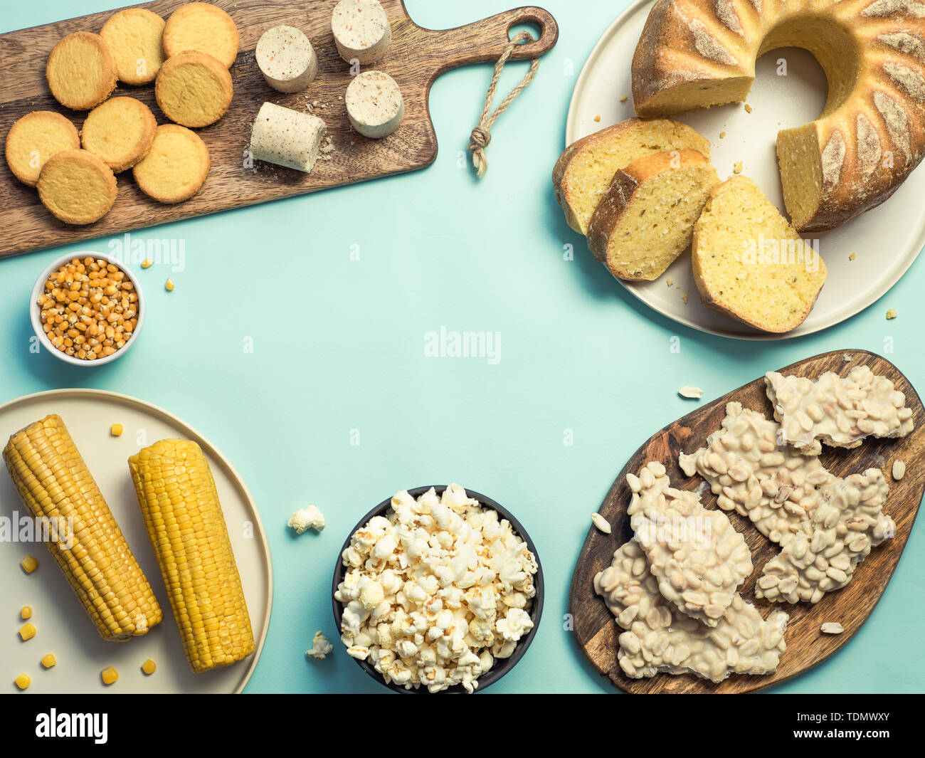 Festa Junina cibo tradizionale background,copia di spazio per il testo. Dolci deliziosi per brasiliano Festa Junina Party: Torta di farina di mais Bolo de Fuba, mais Biscotti,popcorn,peanut candy Pacoca, mais orecchio vista superiore Foto Stock