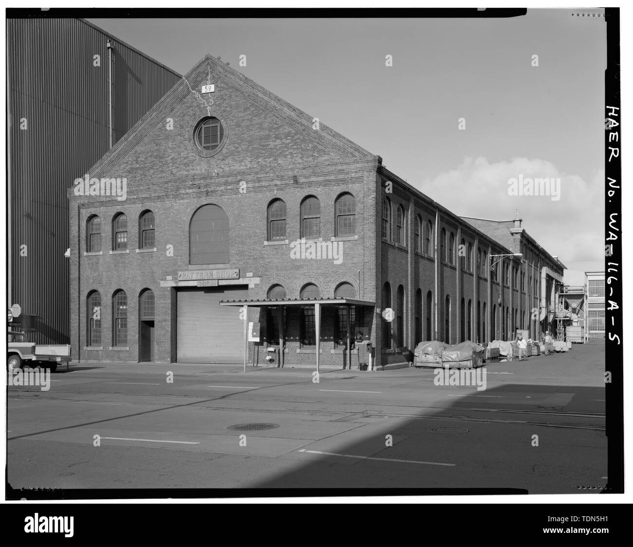 Vista prospettica di sè angolo dell'Edificio 59. In distanza, modifica nota nell'roff linea dove il 1896 sezione sud dell'edificio termina e il 1904 metà sezione inizia. - Puget Sound Naval Shipyard, Pattern Shop, Farragut Avenue, Bremerton, Kitsap County, WA Foto Stock