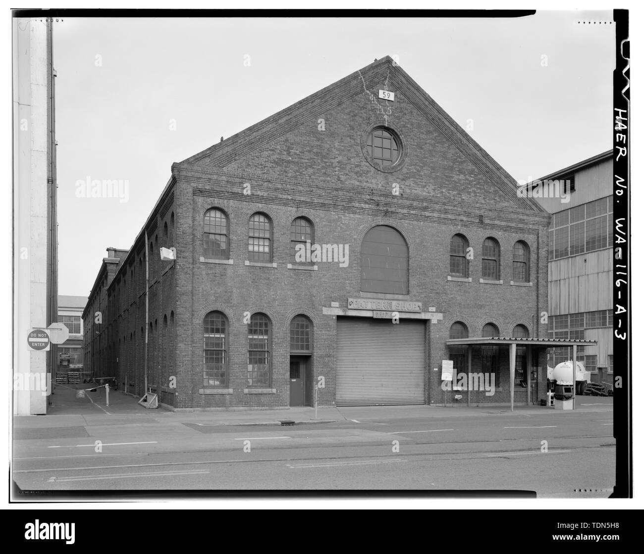 Vista prospettica di SW angolo dell'Edificio 59, che mostra la separazione stretta del lato ovest dell'Edificio 59 dall'Edificio 856. - Puget Sound Naval Shipyard, Pattern Shop, Farragut Avenue, Bremerton, Kitsap County, WA Foto Stock
