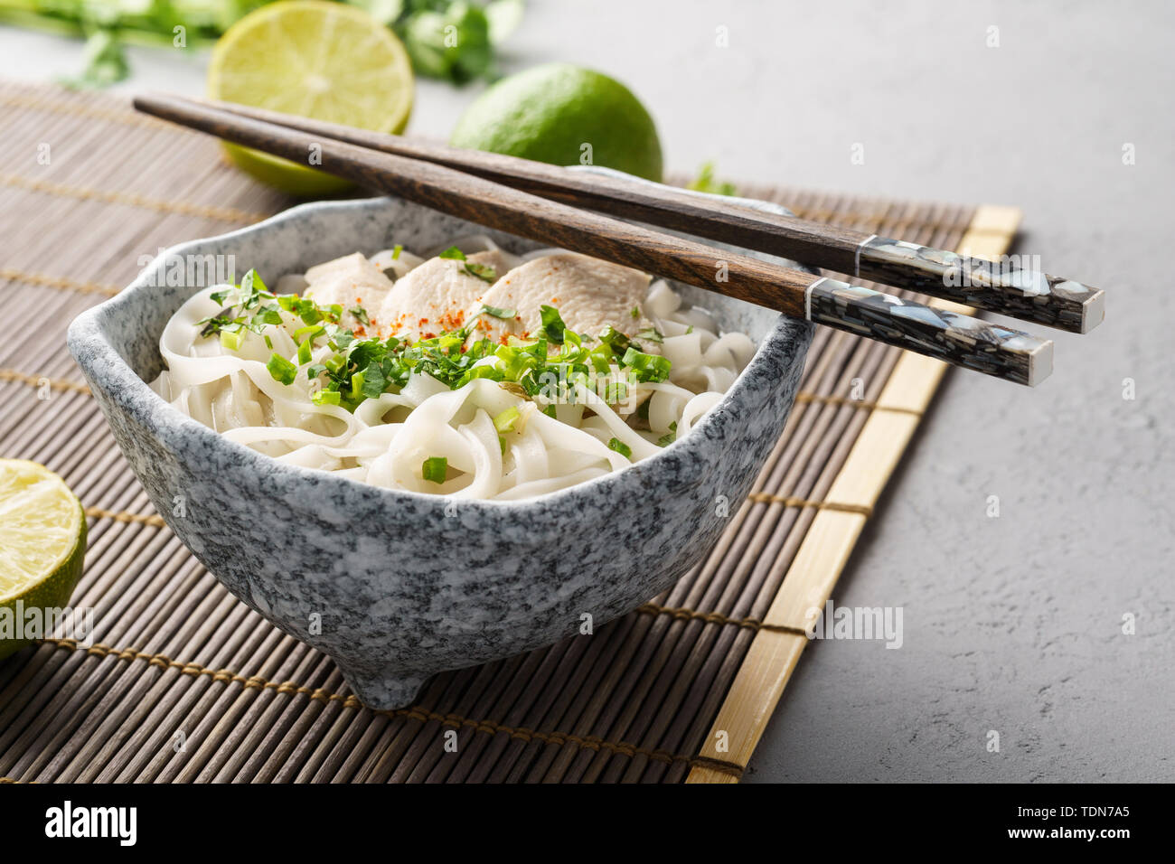 Pho ga, vietnamita riso al pollo noodle soup in una ciotola con bacchette. Foto Stock