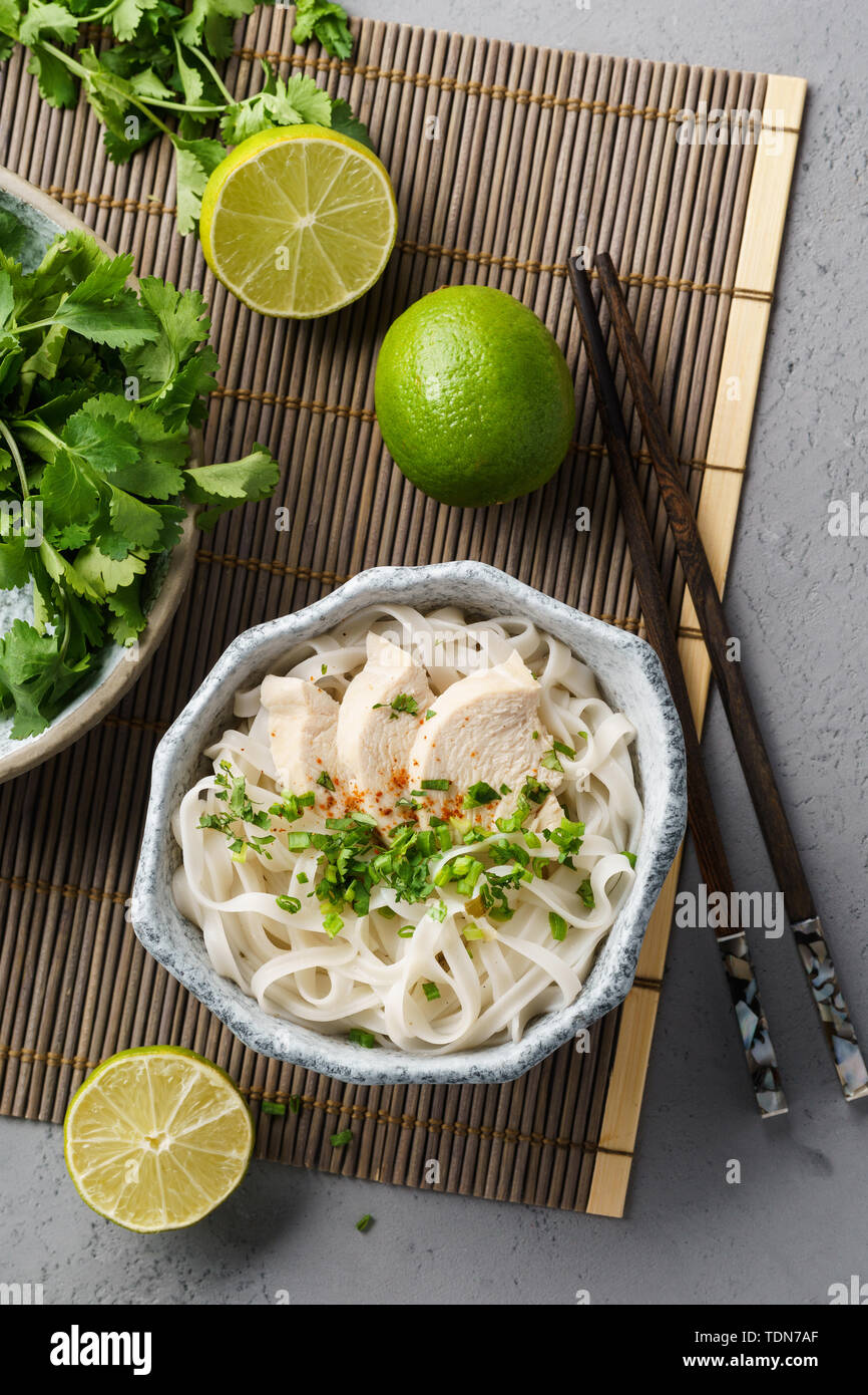 Zuppa vietnamita pho ga con pollo, riso tagliatelle e erbe aromatiche fresche in una ciotola. Foto Stock