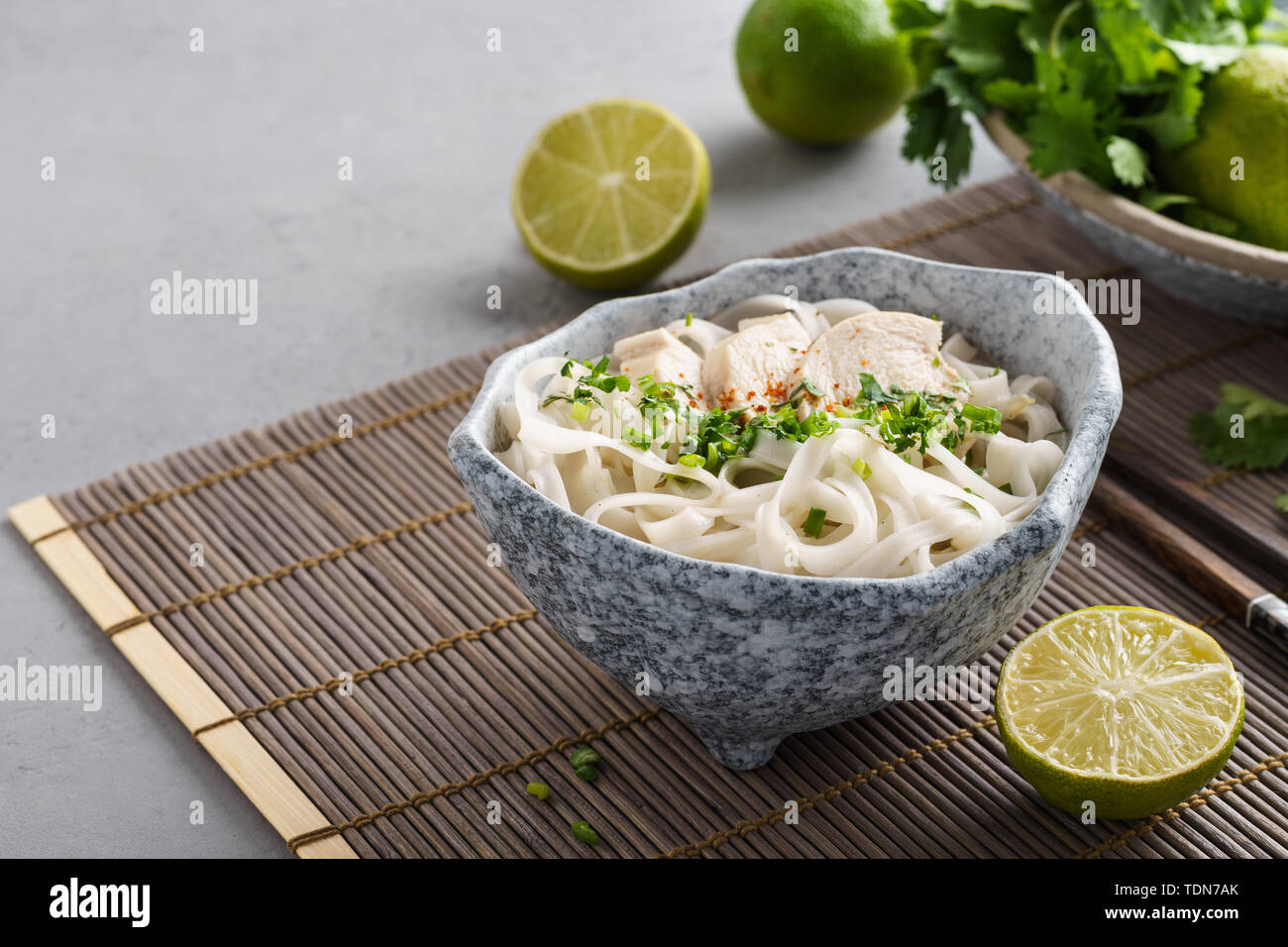 Zuppa vietnamita pho ga con pollo, riso tagliatelle e erbe aromatiche fresche in una ciotola. Spazio per il testo. Foto Stock