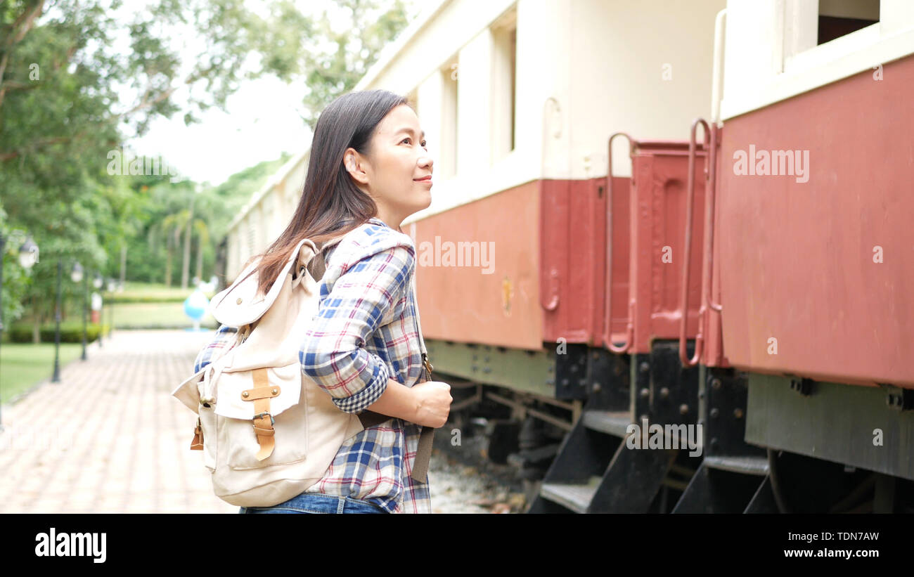 Felice asiatica donna turistica con zaino a piedi al treno alla stazione ferroviaria, cominciare a viaggiare soli viaggi in Asia dal treno vintage. turisti tra Foto Stock