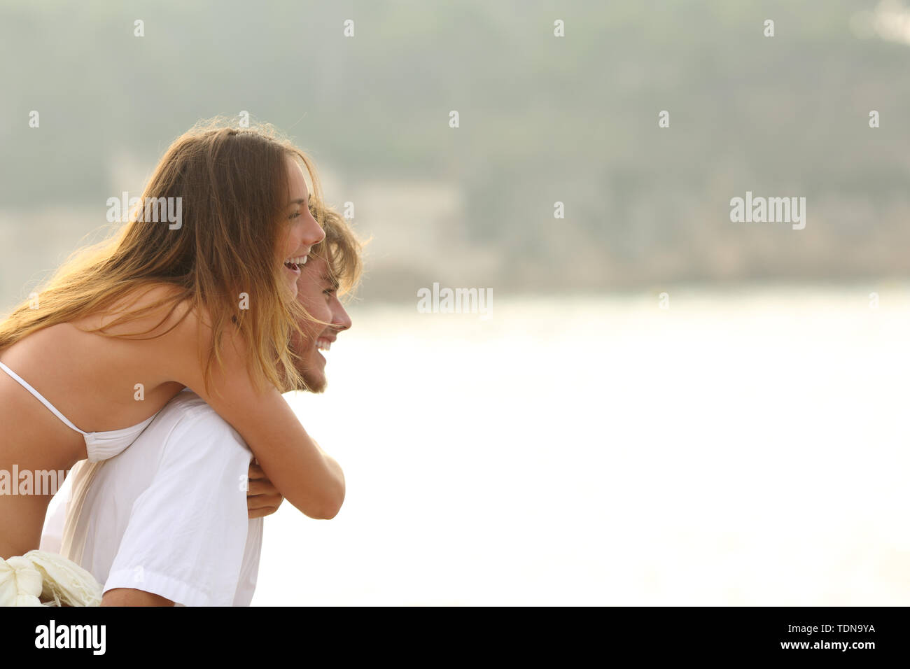 Coppia divertenti scherzi sulla spiaggia con una copia spazio su vacanze estive Foto Stock