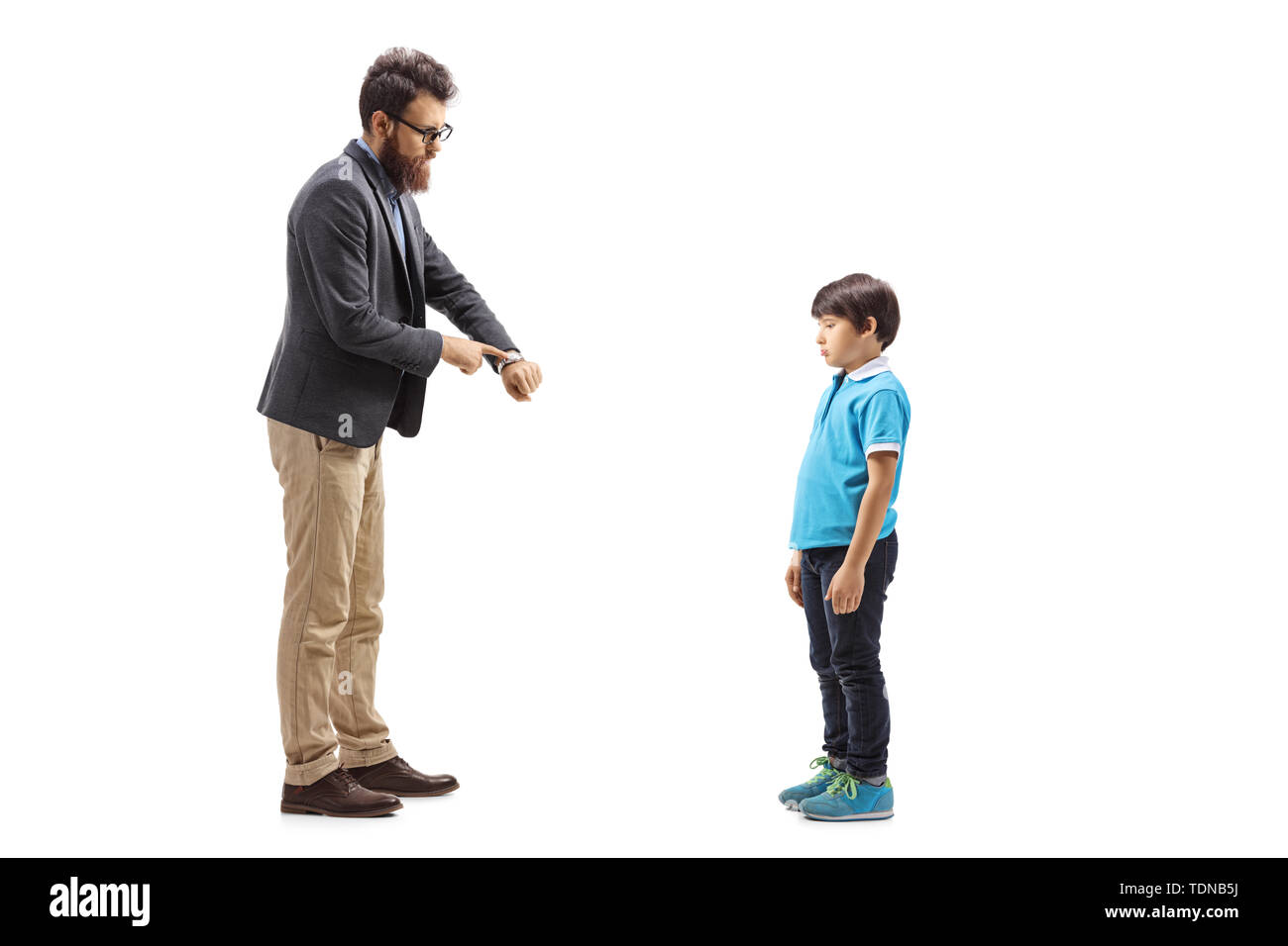 A piena lunghezza shot di un padre scolding suo figlio e guardando questo orologio isolato su sfondo bianco Foto Stock