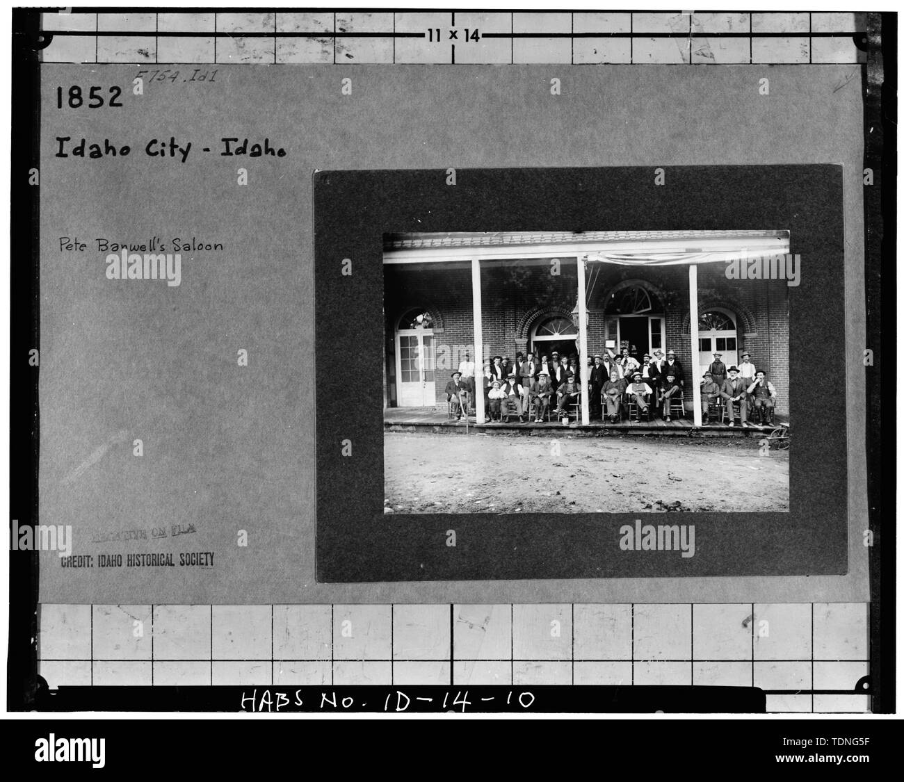 Fotocopia della vecchia foto mostra gli uomini seduti di fronte al salone, tardo XIX o agli inizi del XX secolo. Fotografia originale a Idaho Historical Society, Boise, Idaho. - Dei minatori Scambio di blocco, principali e le strade di parete, Idaho città, contea di Boise, ID Foto Stock