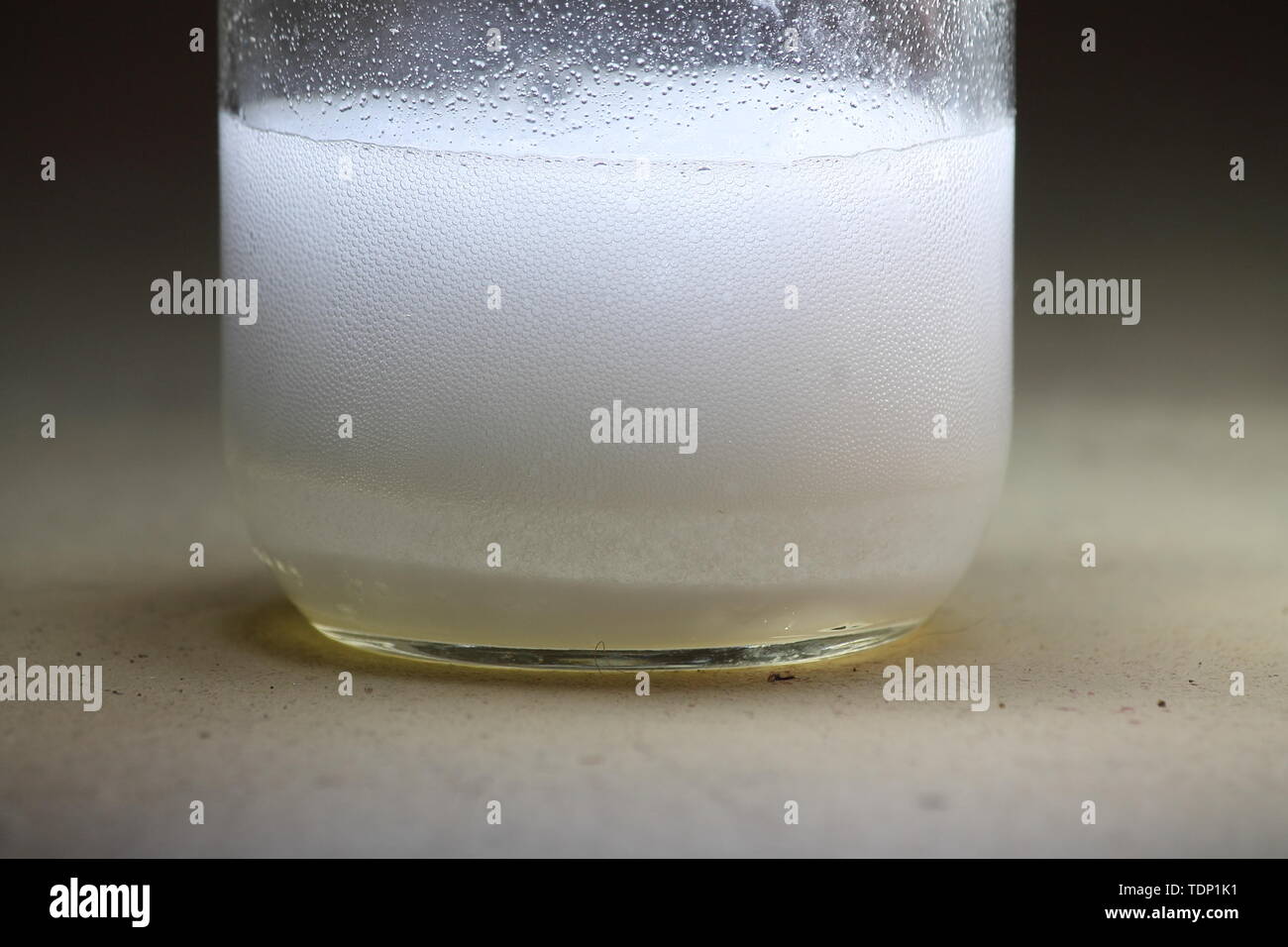 Primo piano di un aceto e bicarbonato di sodio la reazione avvenendo nel fondo di un barattolo di vetro; generare un sacco di elementi animati Foto Stock