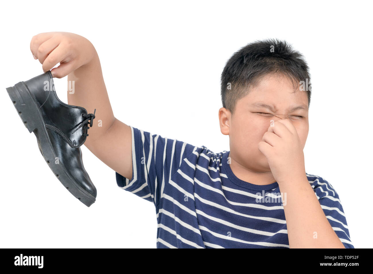 Disgustato fat boy tenendo un paio di puzzolente e puzzolente e scarpe di cuoio isolati su sfondo bianco, Health care concept Foto Stock