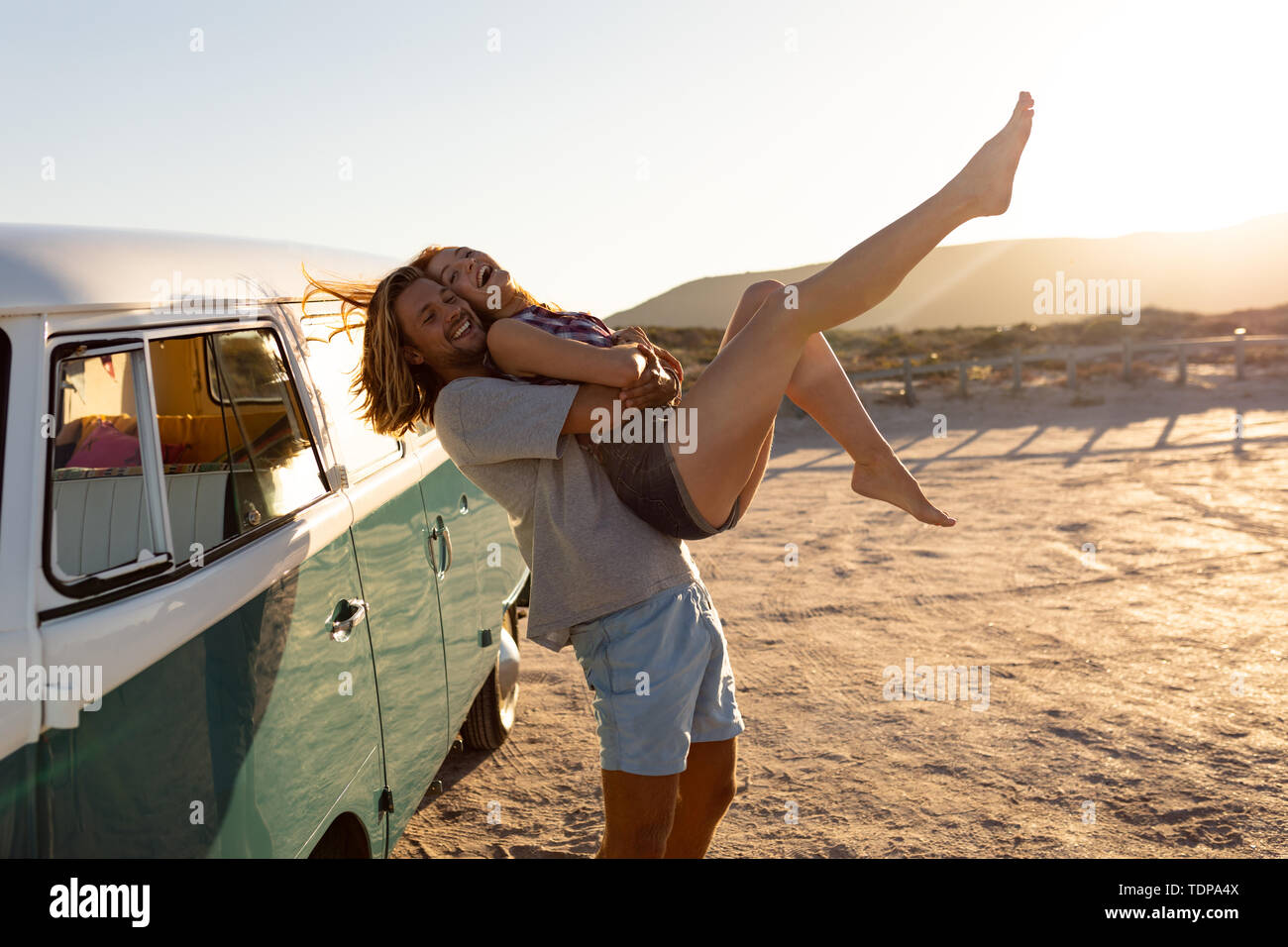 Uomo con la donna vicino a camper van a beach Foto Stock