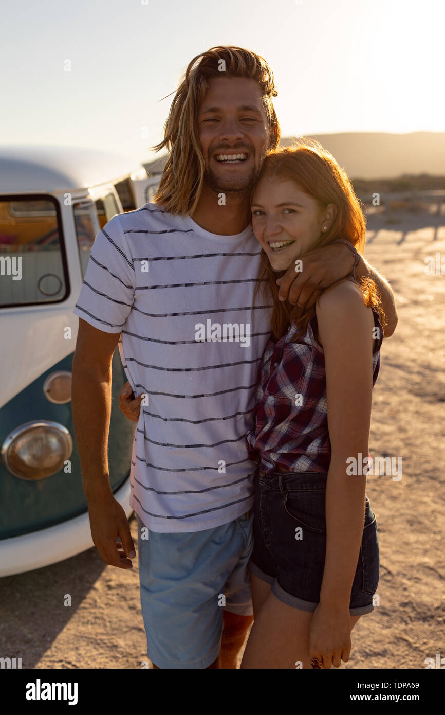 Felice coppia giovane che abbraccia ogni altra vicino camper presso la spiaggia Foto Stock