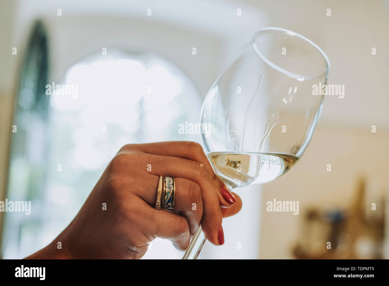 Una donna di mano trattiene con un bicchiere di vino bianco; Italia; Italia Foto Stock