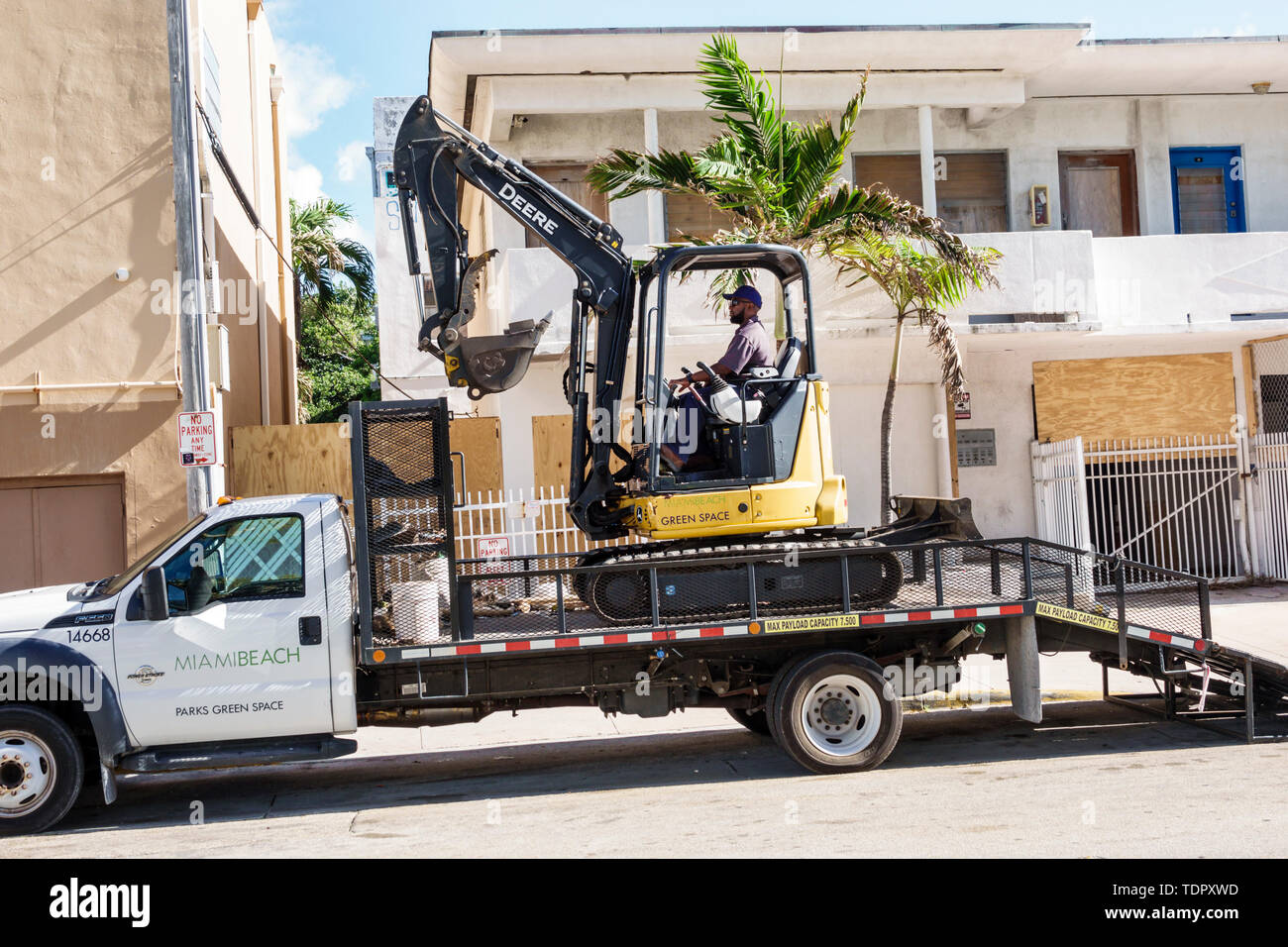 Miami Beach Florida,North Beach,City of,Miami Beach,Green Space Parks Department,attrezzatura da costruzione,escavatore compatto,John Deere,camion,uomo male Foto Stock