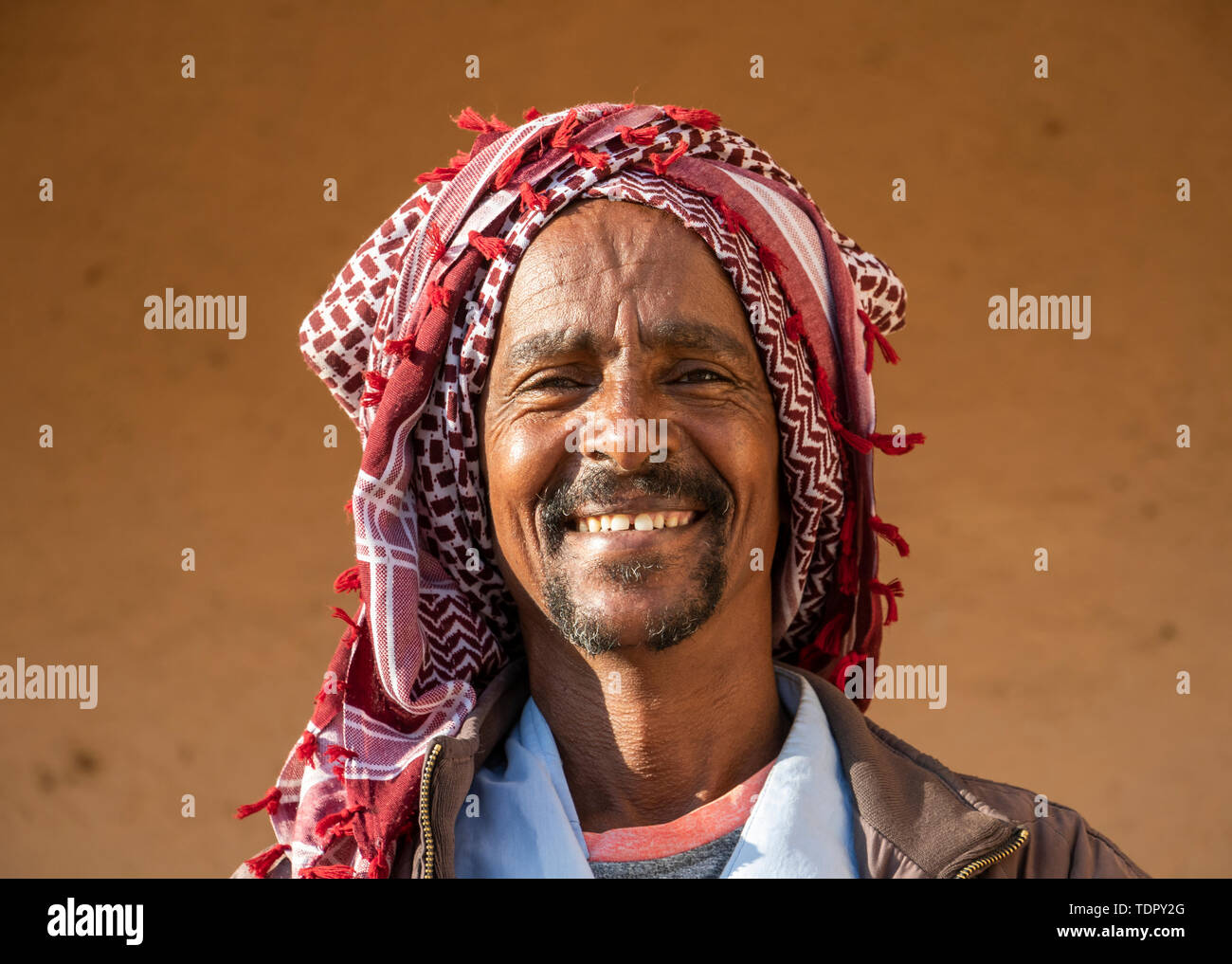 Ritratto di un uomo eritreo sorridente con un velo sul suo capo, lunedì mercato del bestiame; Keren, Anseba Regione, Eritrea Foto Stock