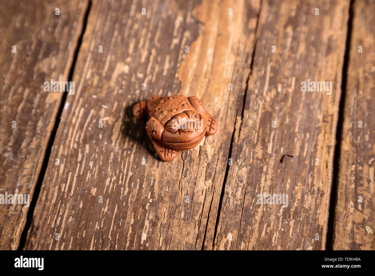 Rana cinese poco figurina portachiavi su un vecchio tavolo in legno Foto Stock