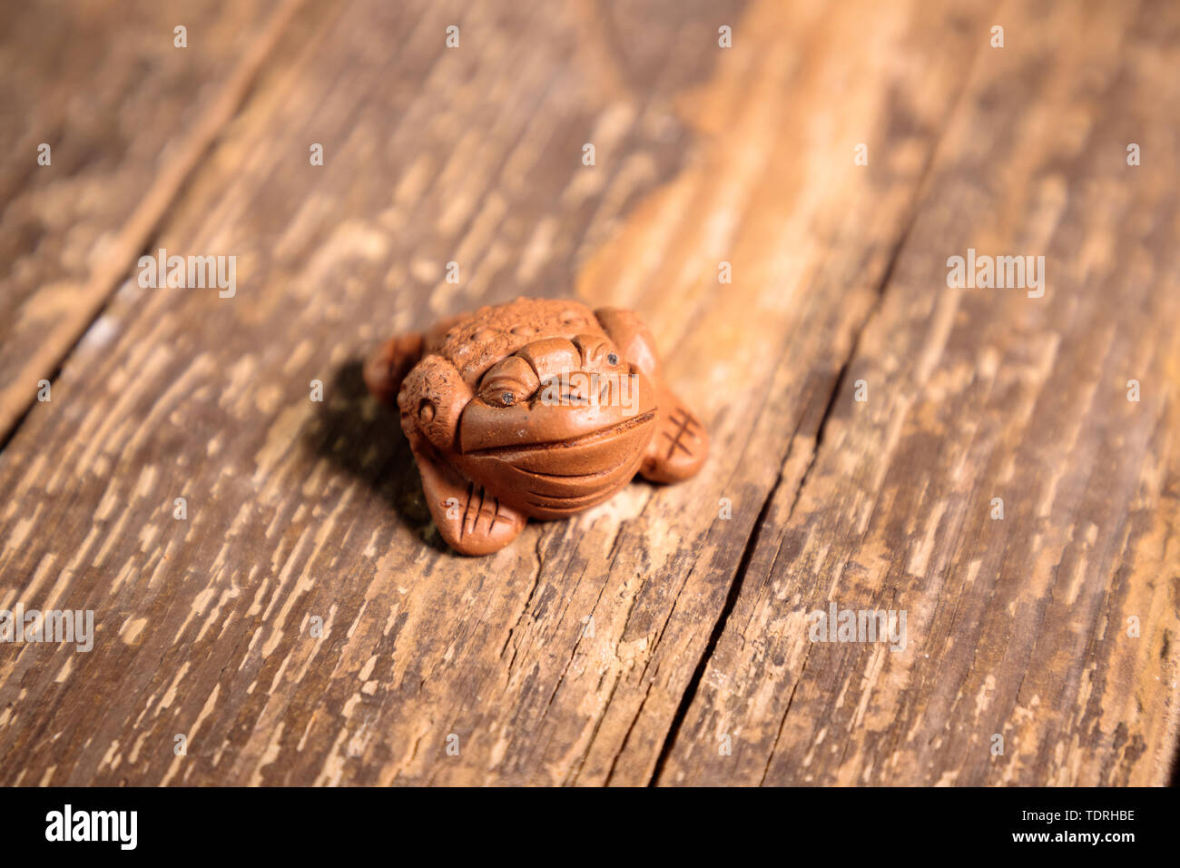 Rana cinese poco figurina portachiavi su un vecchio tavolo in legno Foto Stock