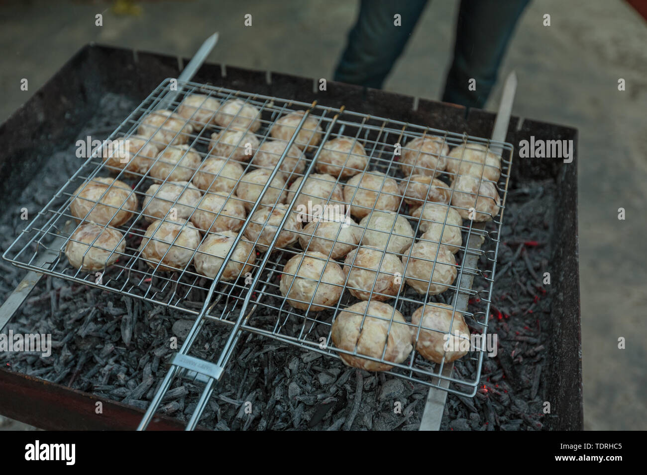 I funghi vengono fritte in carbone di legna sulle braci nel pomeriggio Foto Stock